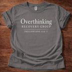 Gray t-shirt with 'Overthinking Recovery Group Philippians 4:6-7' text on a wooden surface