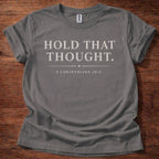 Gray t-shirt with 'Hold That Thought' text on a wooden surface