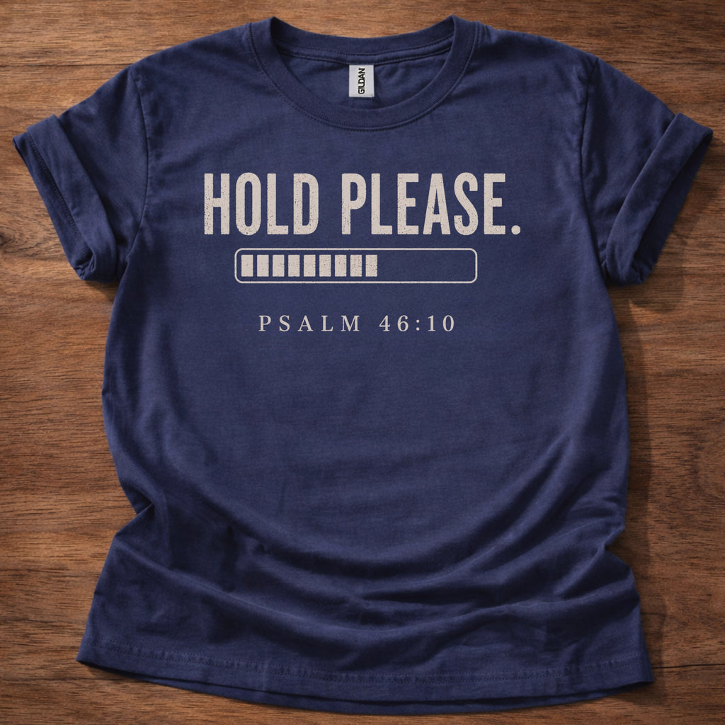 Navy blue t-shirt with 'Hold Please. Psalm 46:10' text on a wooden surface
