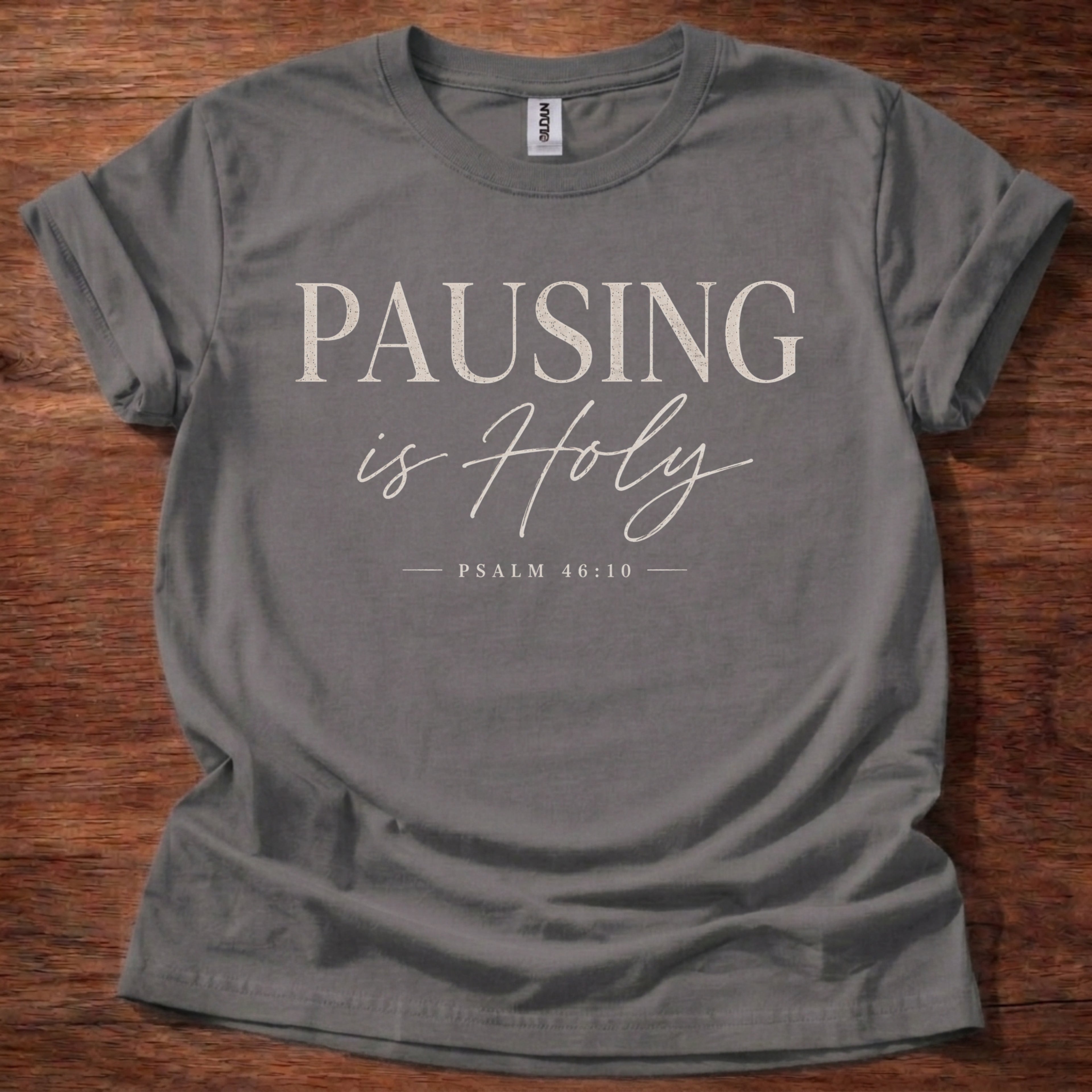 Gray t-shirt with 'Find Rest' text on a wooden surface