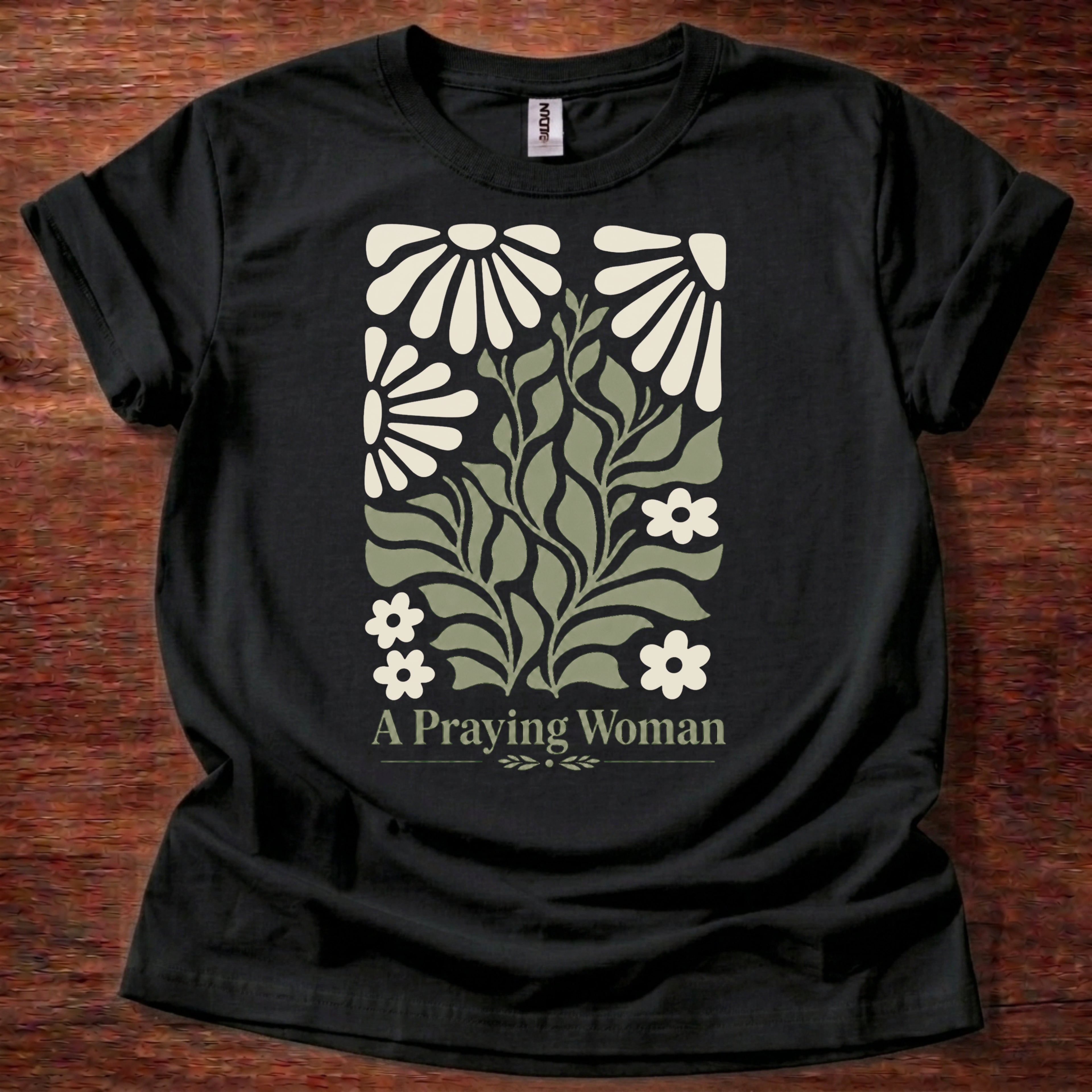 Black t-shirt featuring a floral design with the phrase “A Praying Woman” printed on the front