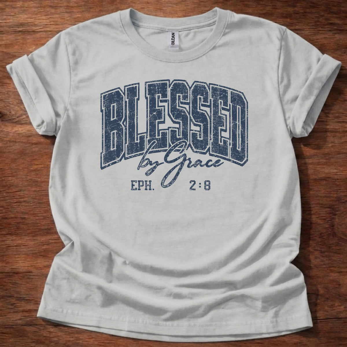 Navy distressed varsity-style t-shirt reading 'Blessed by Grace' with cursive script and Ephesians 2:8 citation