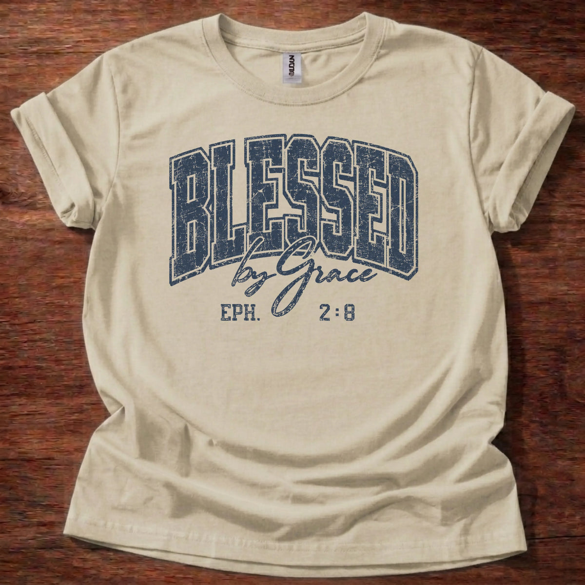Navy distressed varsity-style t-shirt reading 'Blessed by Grace' with cursive script and Ephesians 2:8 citation