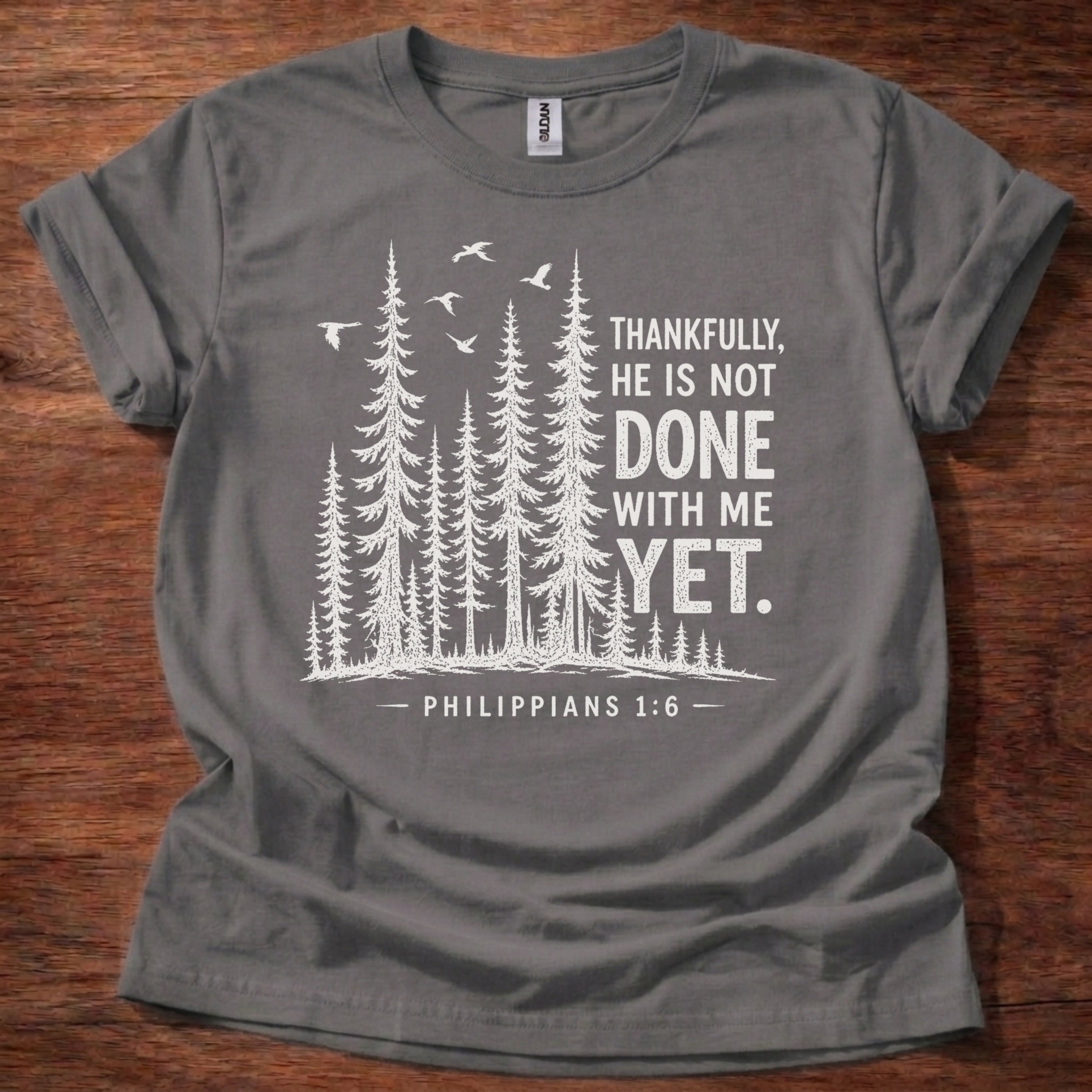 Charcoal Christian t-shirt with forest graphic and “Thankfully, He is not done with me yet” Philippians 1:6 design