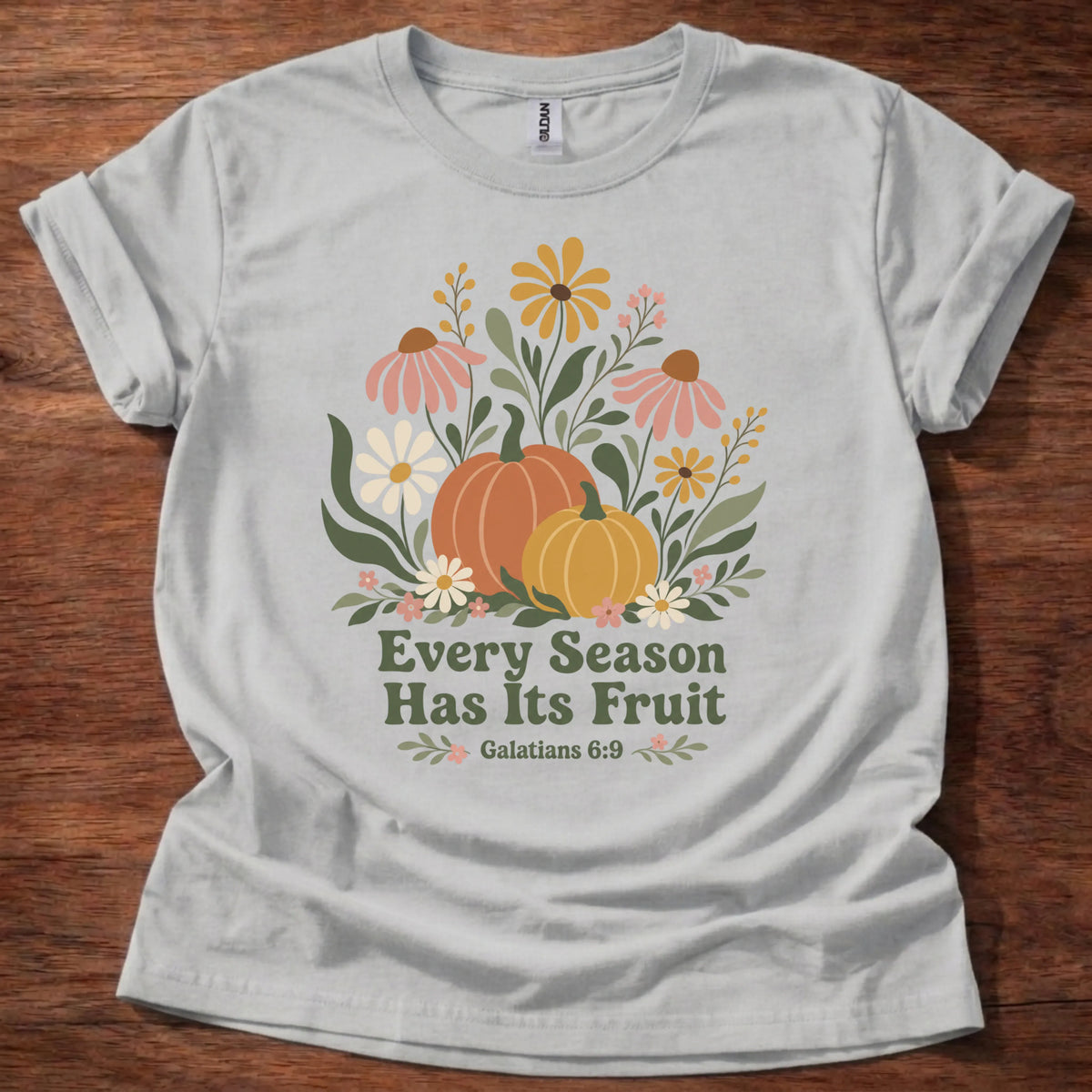 Colorful floral and pumpkin illustration t-shirt with the text 'Every Season Has Its Fruit' and Galatians 6:9
