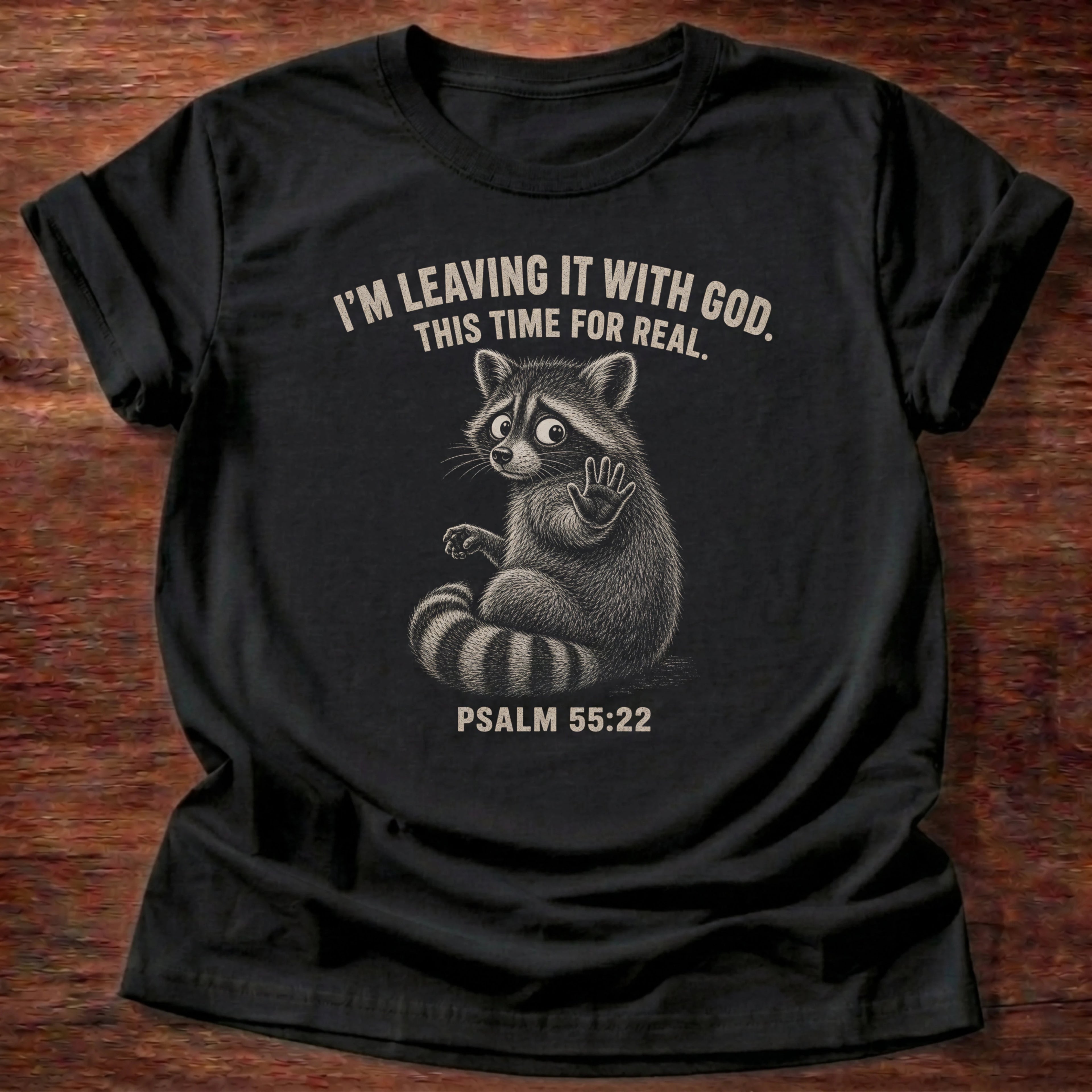 Black t-shirt with a raccoon illustration reading 'I'm leaving it with God, this time for real' Psalm 55:22 Christian shirt