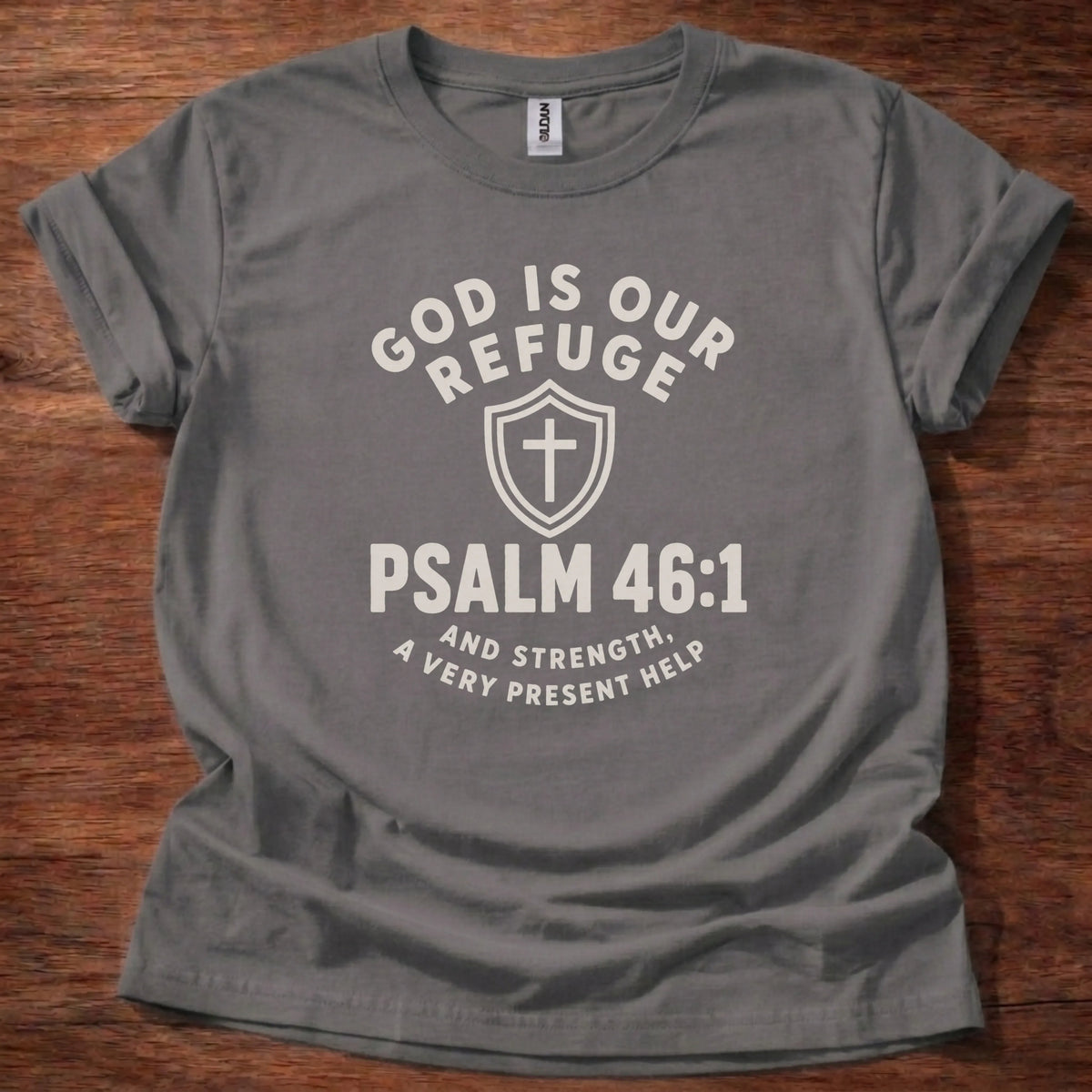 Cream shield and cross icon t-shirt with the text 'God Is Our Refuge' arched above and 'Psalm 46:1' below