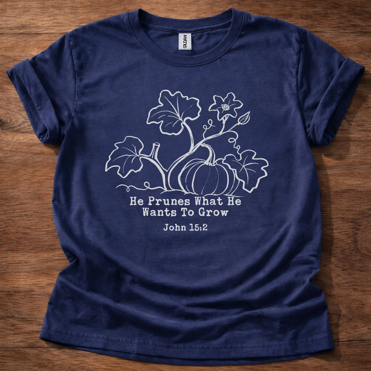 Cream tonal pumpkin vine illustration t-shirt with the text 'He Prunes What He Wants To Grow' and John 15:2