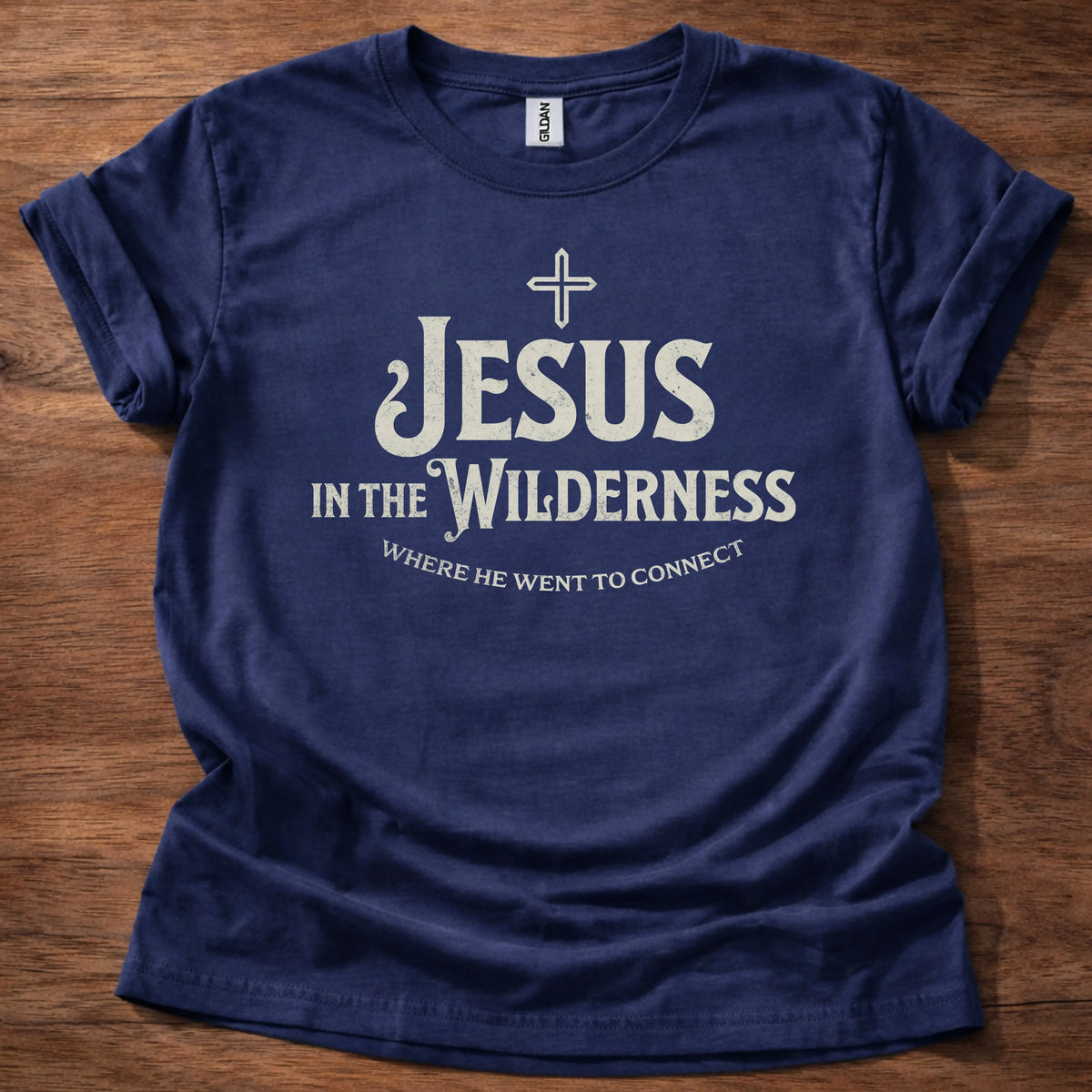 Cream vintage-lettering t-shirt with a small cross icon and the text 'Jesus In The Wilderness, Where He Went To Connect'