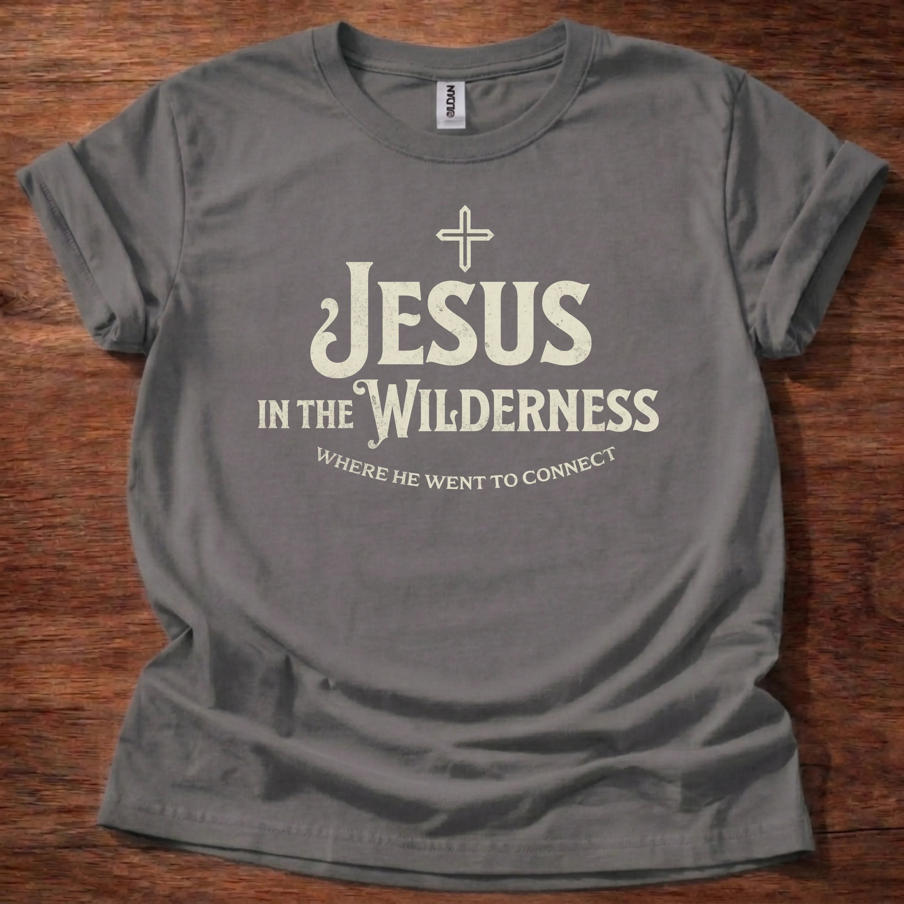 Cream vintage-lettering t-shirt with a small cross icon and the text 'Jesus In The Wilderness, Where He Went To Connect'