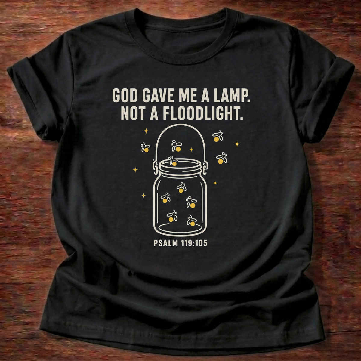 Black t-shirt printed with jar of light graphic and 'God gave me a lamp, not a floodlight,' a Psalm 119:105 faith based gift