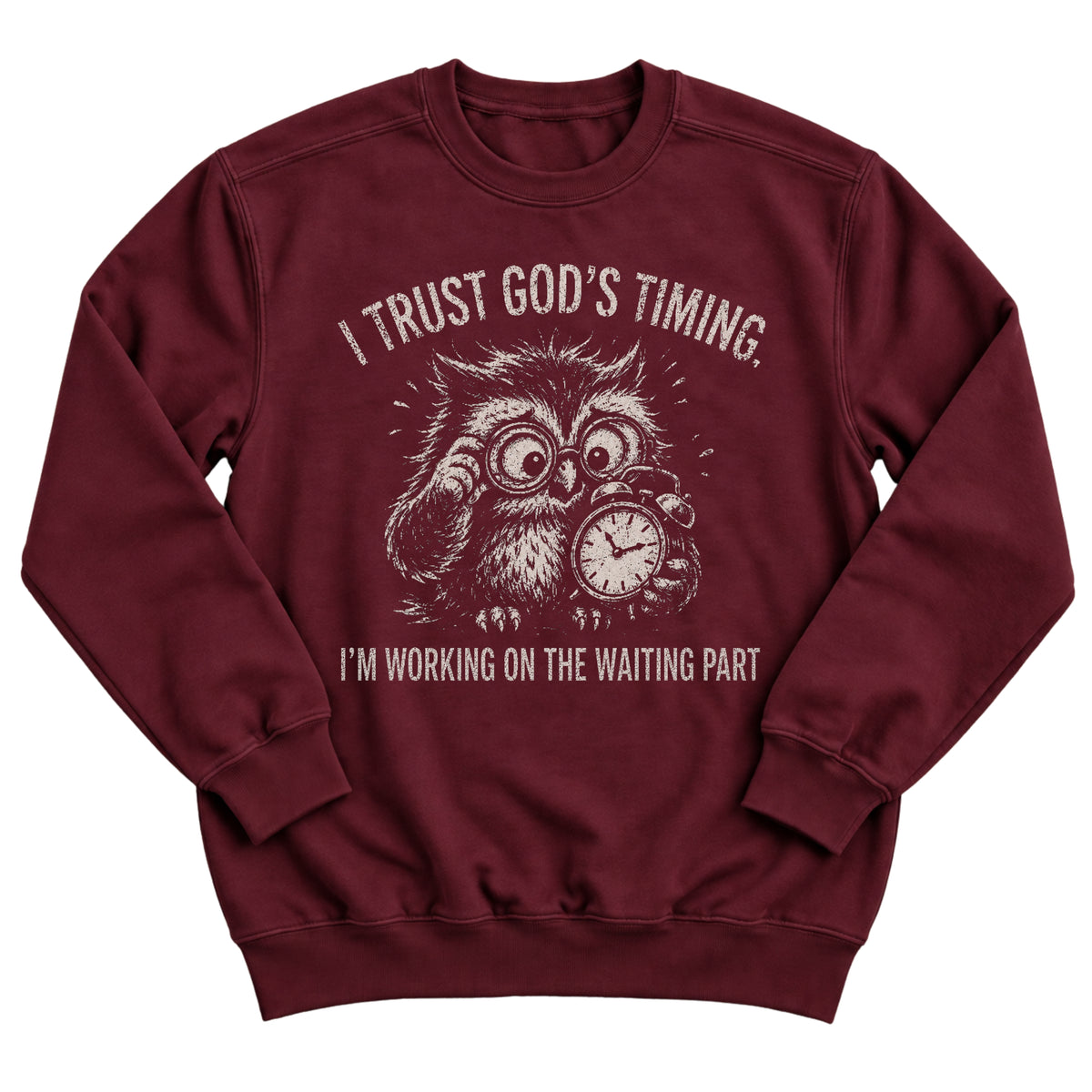 Maroon crewneck sweatshirt with a frazzled owl in glasses clutching a clock and the words I Trust God's Timing. I'm Working On The Waiting Part.