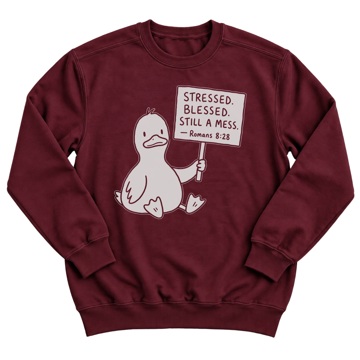 Maroon crewneck sweatshirt with a cartoon duck sitting and holding a sign that reads Stressed. Blessed. Still A Mess. Romans 8:28