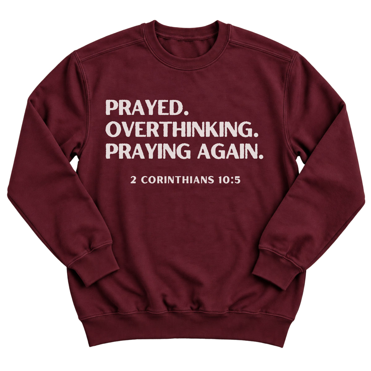 Maroon crewneck sweatshirt with bold stacked lettering reading Prayed. Overthinking. Praying Again. with 2 Corinthians 10:5