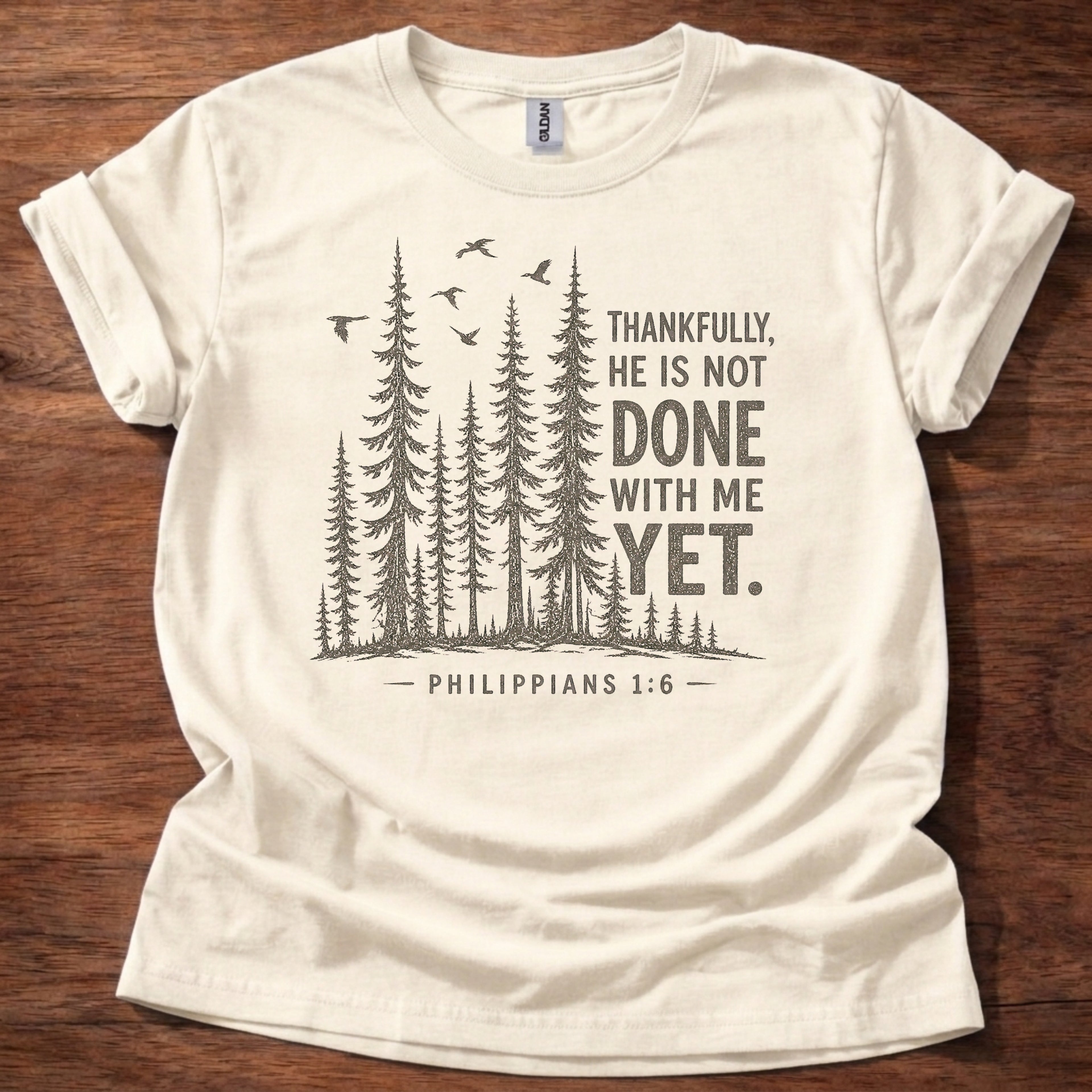 Natural Christian t-shirt with forest graphic and “Thankfully, He is not done with me yet” Philippians 1:6 design