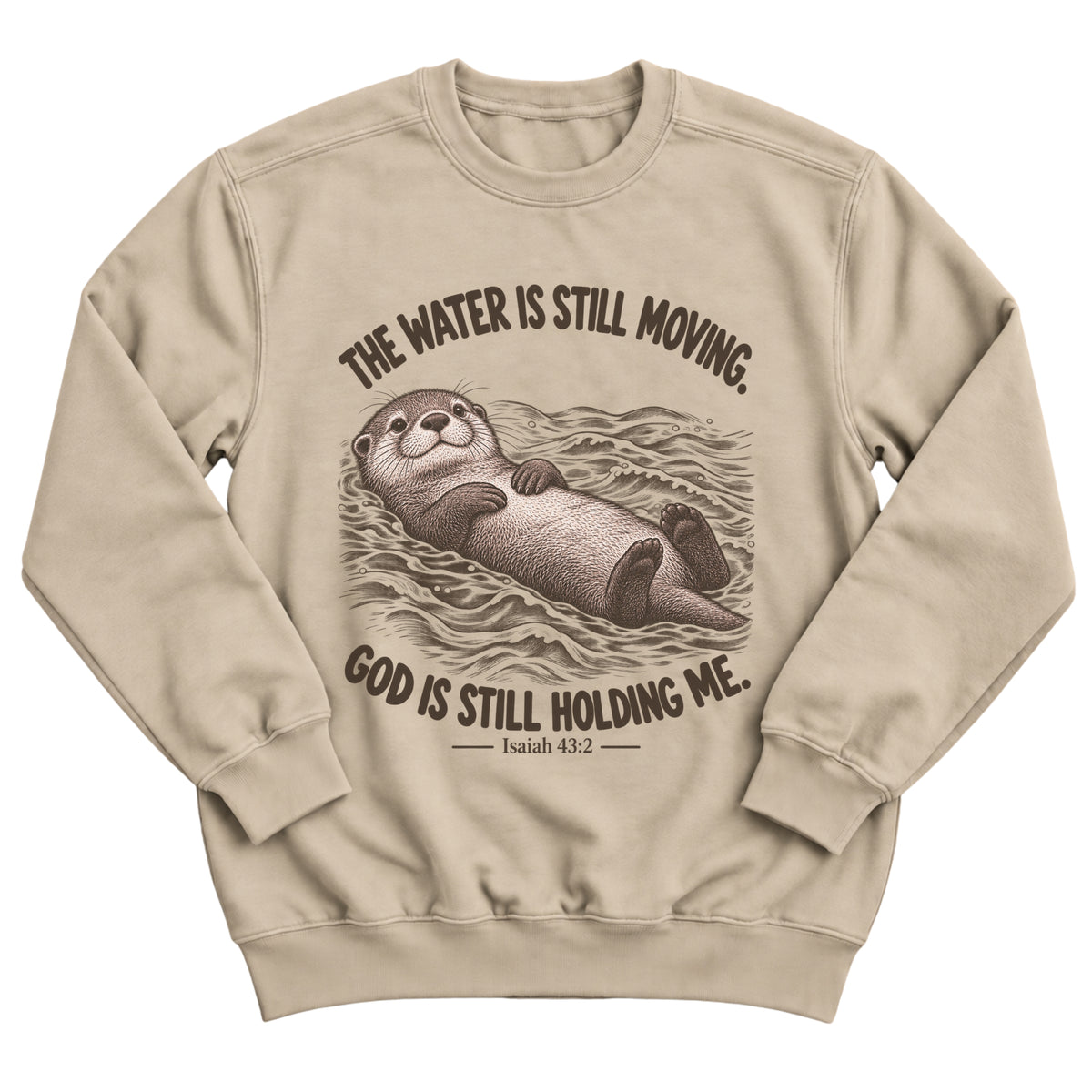 Sand crewneck sweatshirt with an otter floating peacefully on rippling water and the words The Water Is Still Moving. God Is Still Holding Me. Isaiah 43:2