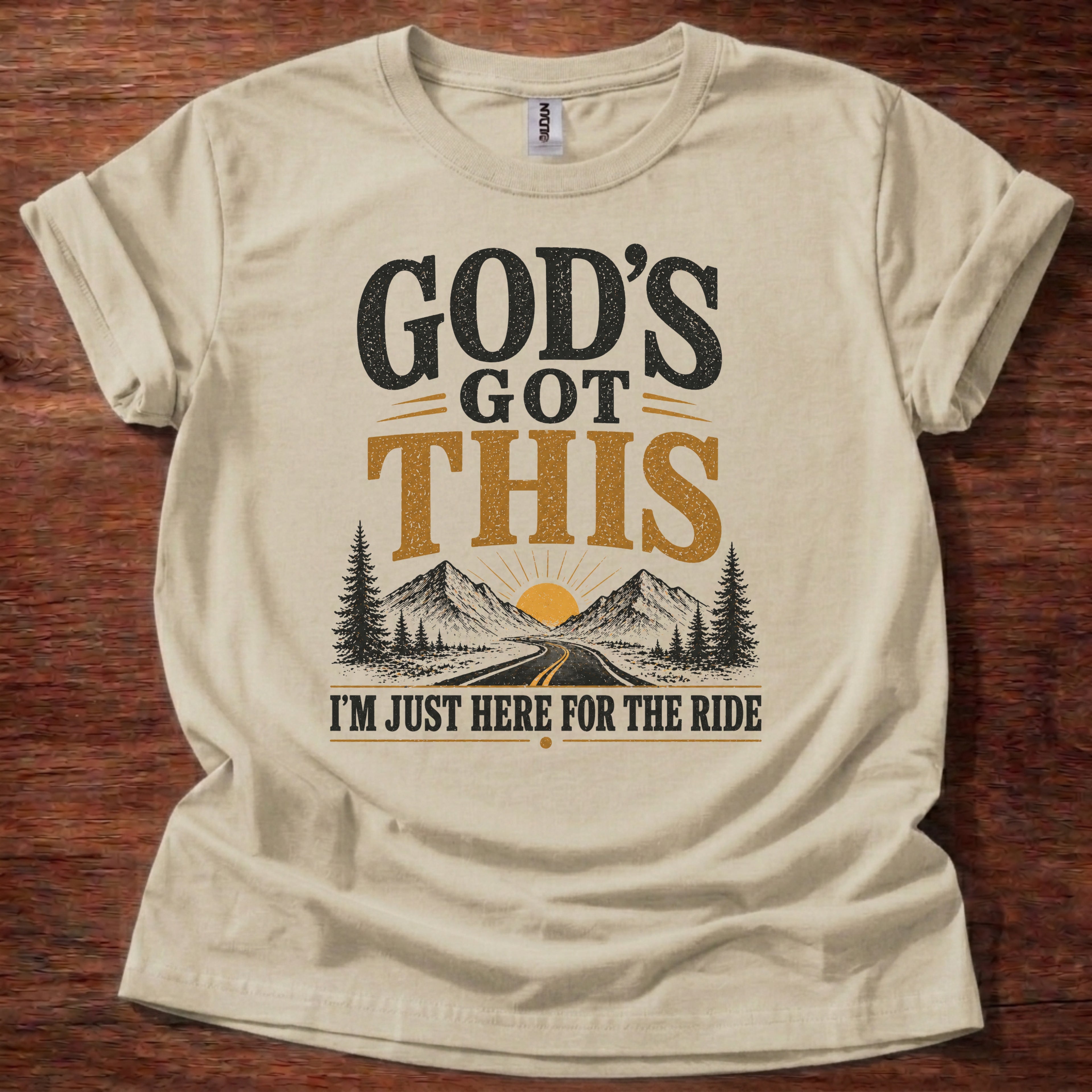 Sand God’s Got This I’m Just Here for the Ride Christian shirt with mountain and sunrise graphic on beige t-shirt, inspirational faith design