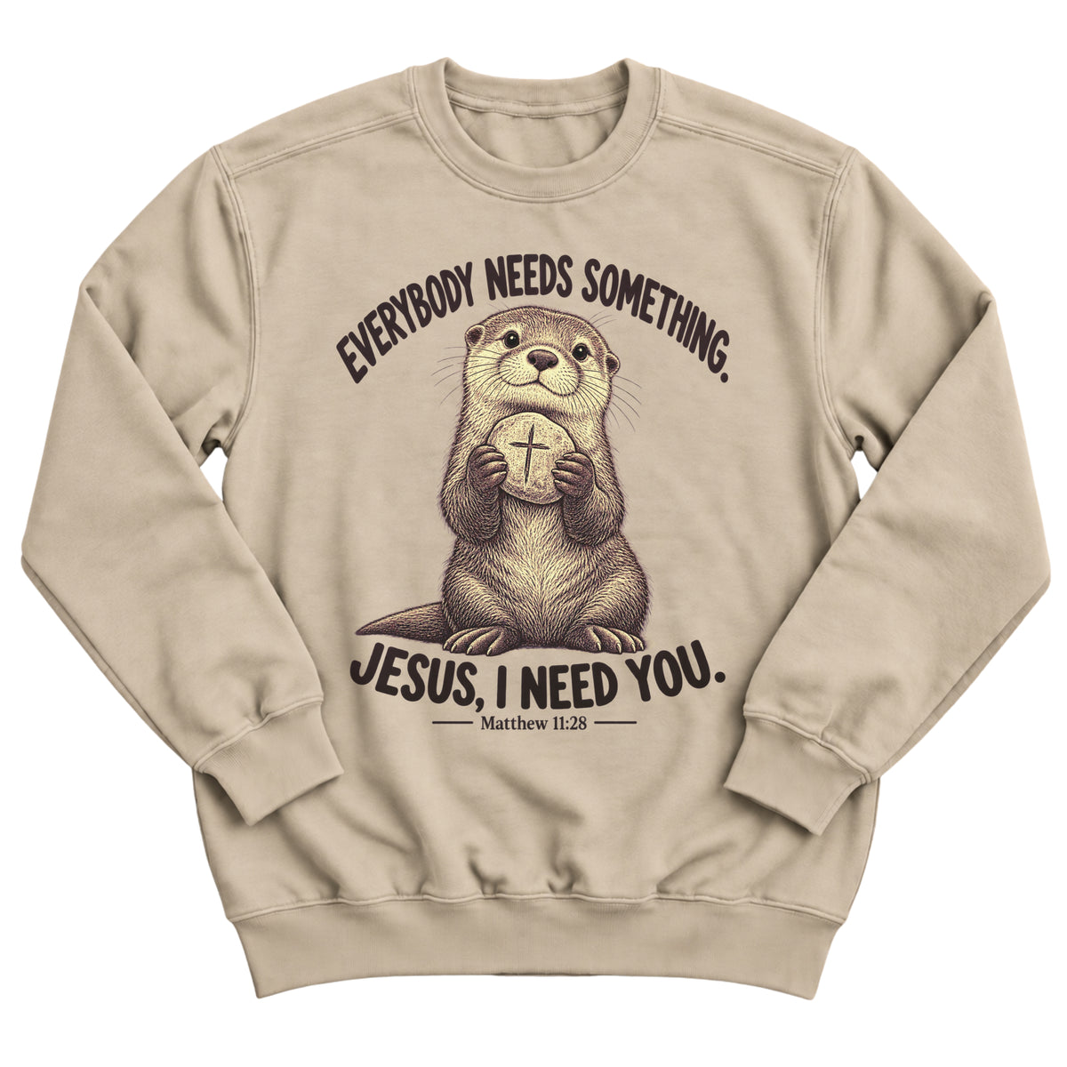 Sand crewneck sweatshirt with a sweet otter illustration holding a round cross-marked token and the words Everybody Needs Something. Jesus, I Need You. Matthew 11:28