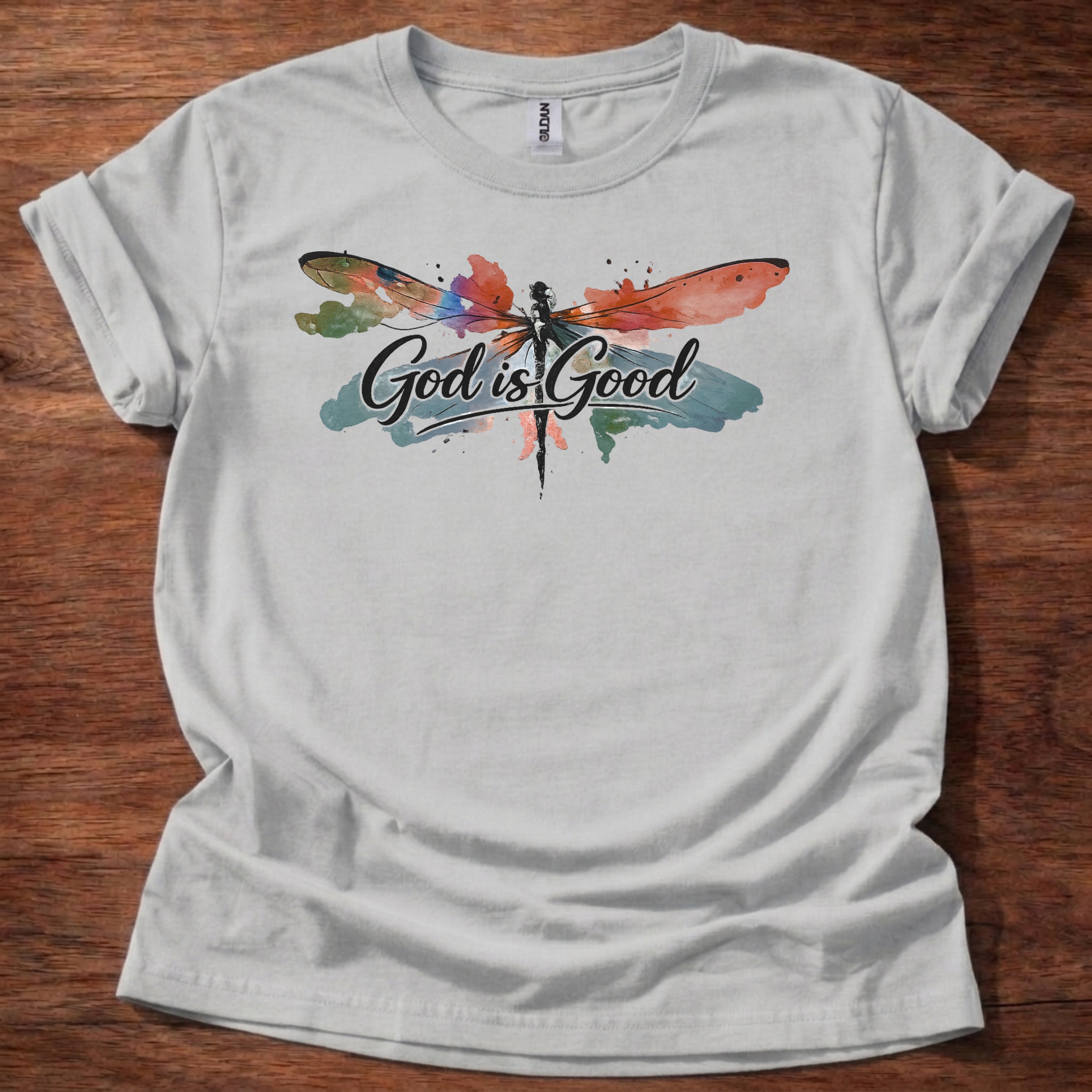 Sport Grey t-shirt featuring a colorful watercolor dragonfly design with the words “God is Good” printed across the front