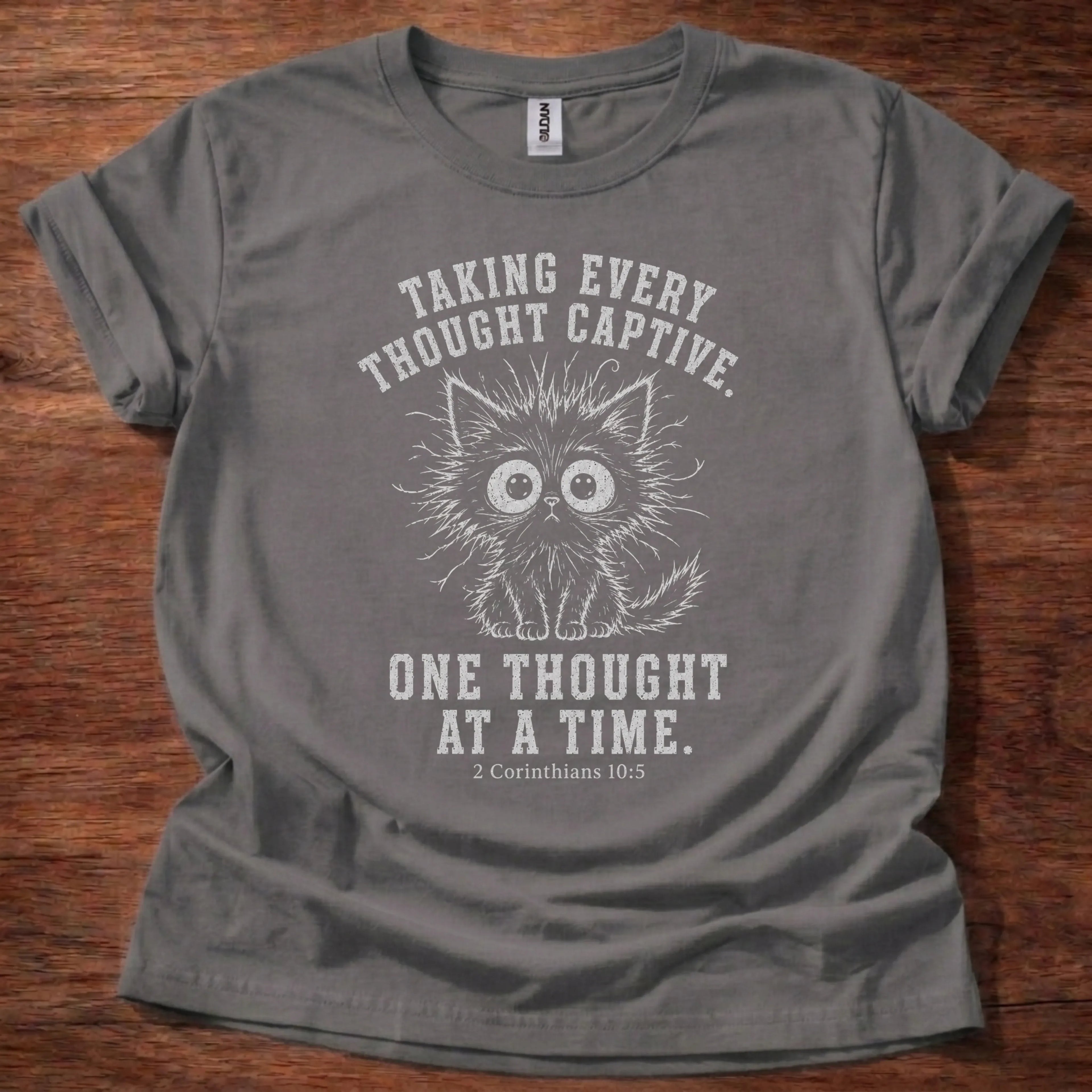White fine-line kitten illustration t-shirt with the text 'Taking Every Thought Captive. One Thought At A Time.' and 2 Corinthians 10:5
