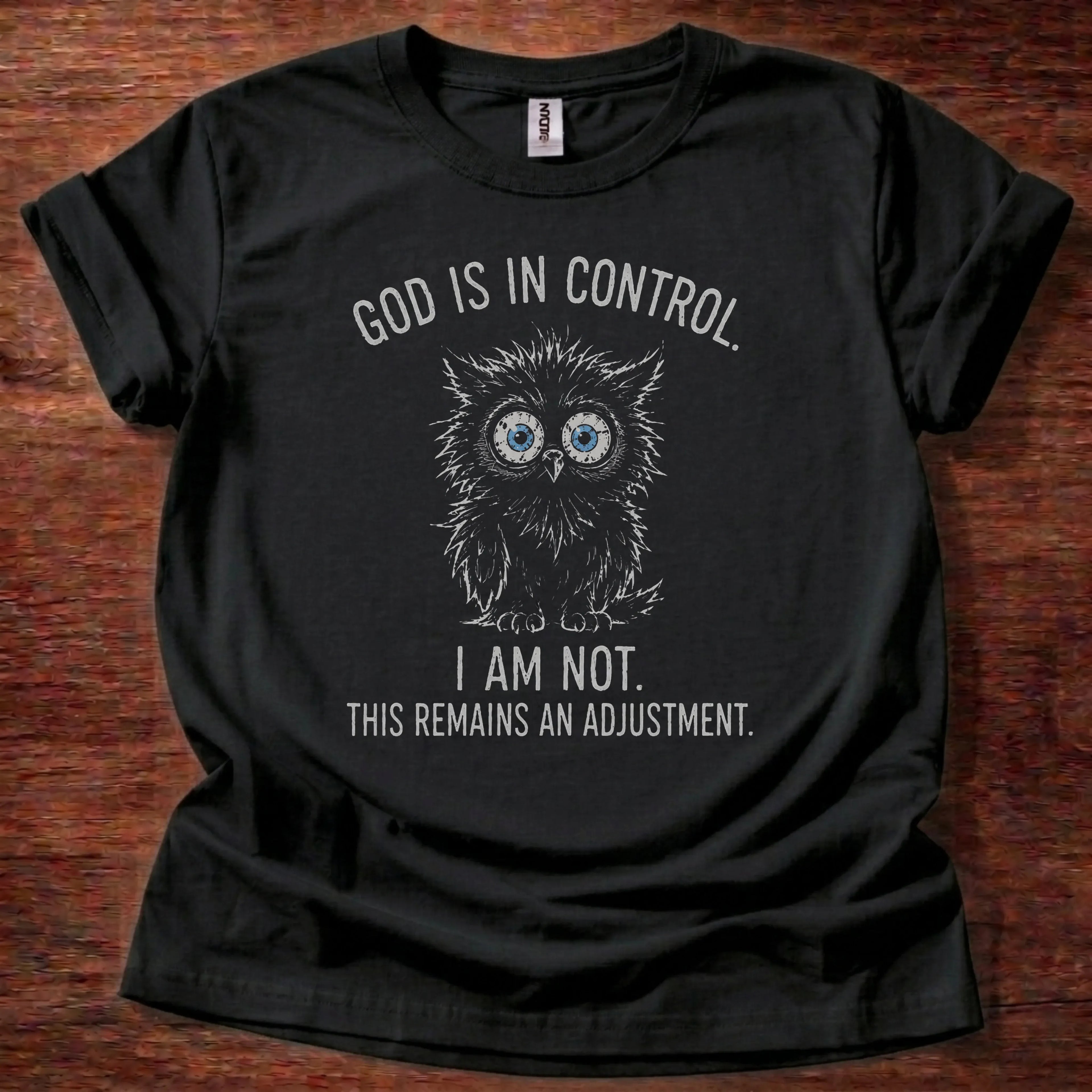 White fine-line owl illustration t-shirt with the text 'God Is In Control. I Am Not. This Remains An Adjustment.' and Isaiah 55:8-9