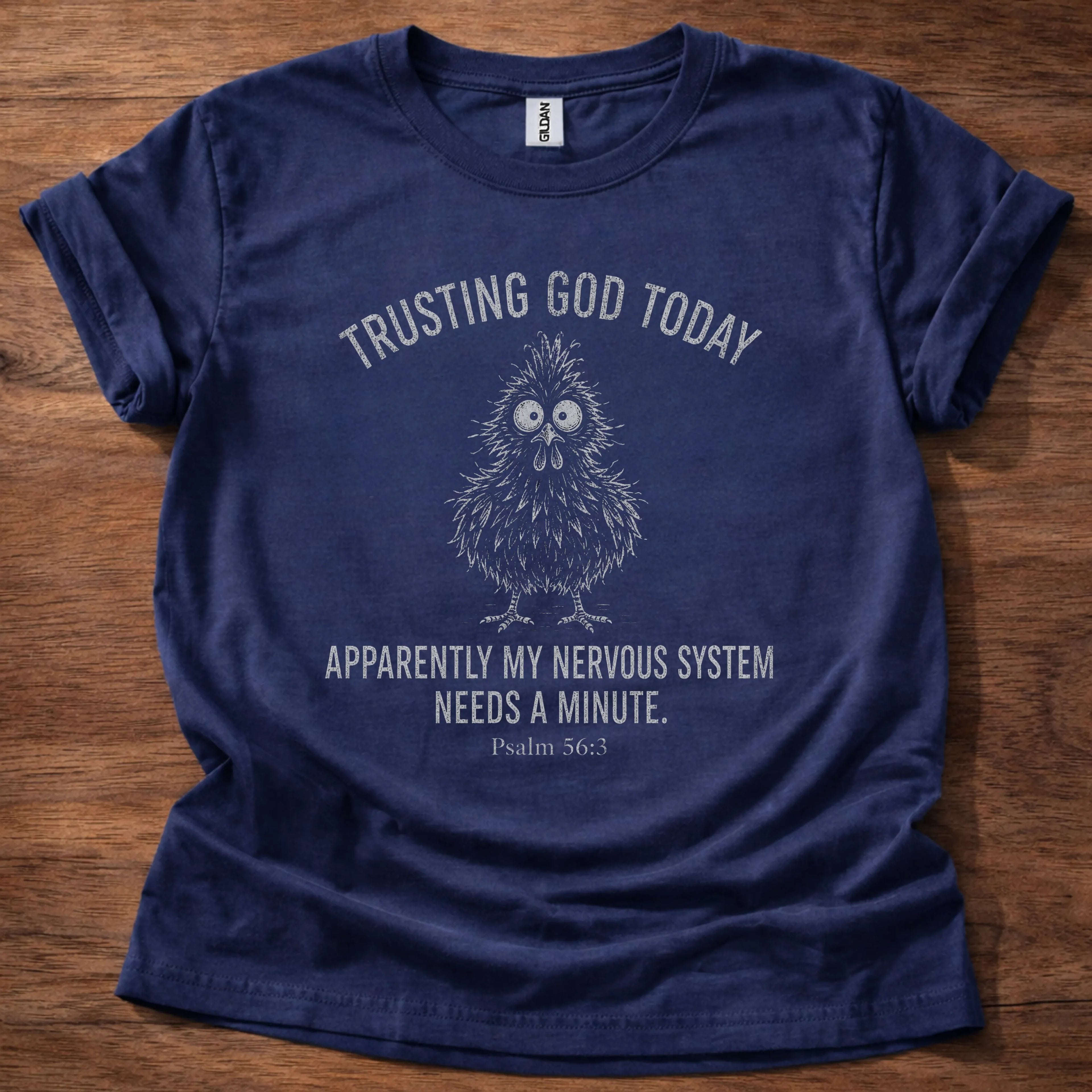 White fine-line chick illustration t-shirt with the text 'Trusting God Today. Apparently My Nervous System Needs A Minute.' and Psalm 56:3