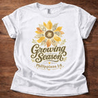 White Growing Season Christian t-shirt with sunflower graphic and Philippians 1:6 scripture design