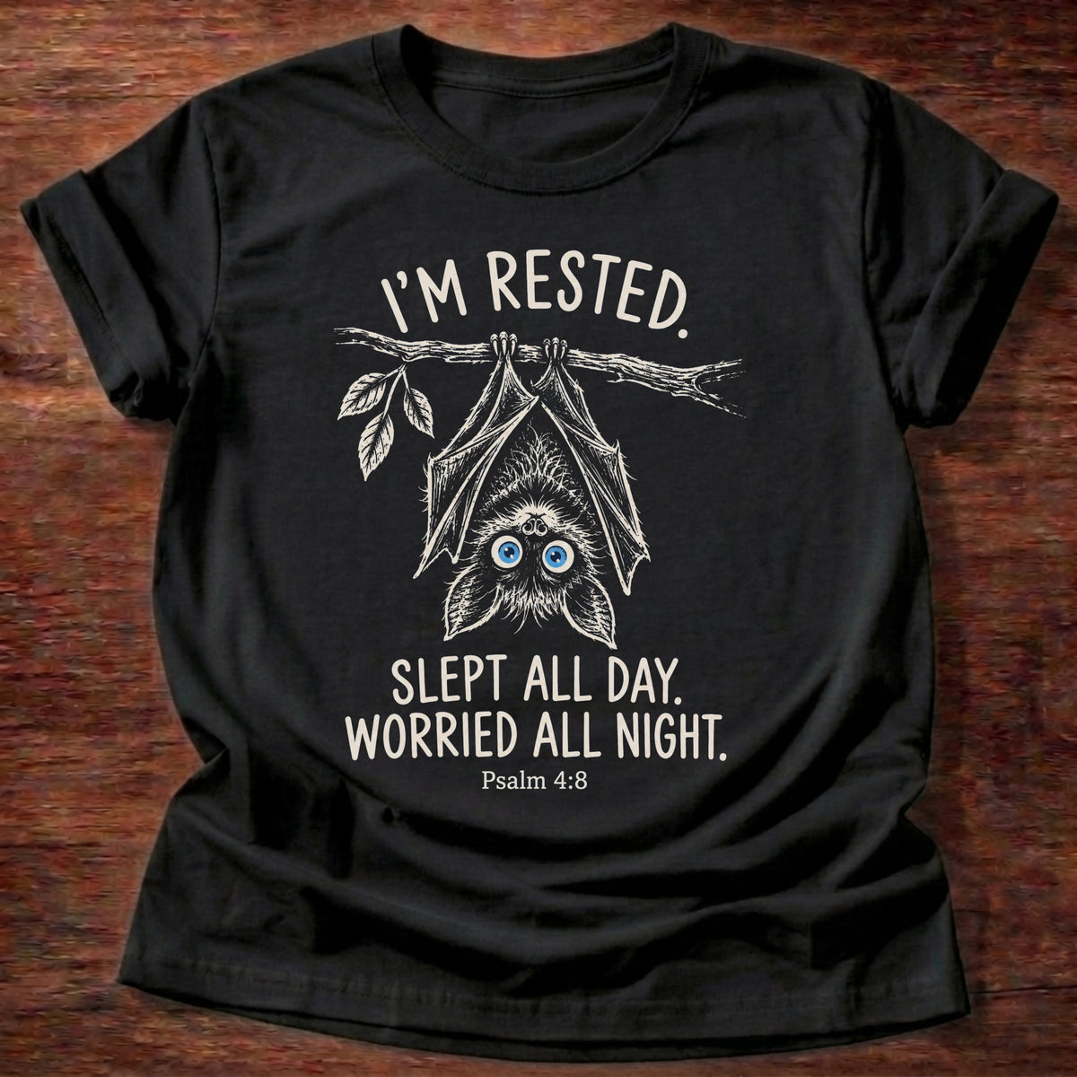 Black t-shirt printed with an upside-down hanging bat graphic and “I'm rested. Slept all day. Worried all night.” Psalm 4:8 Christian shirt