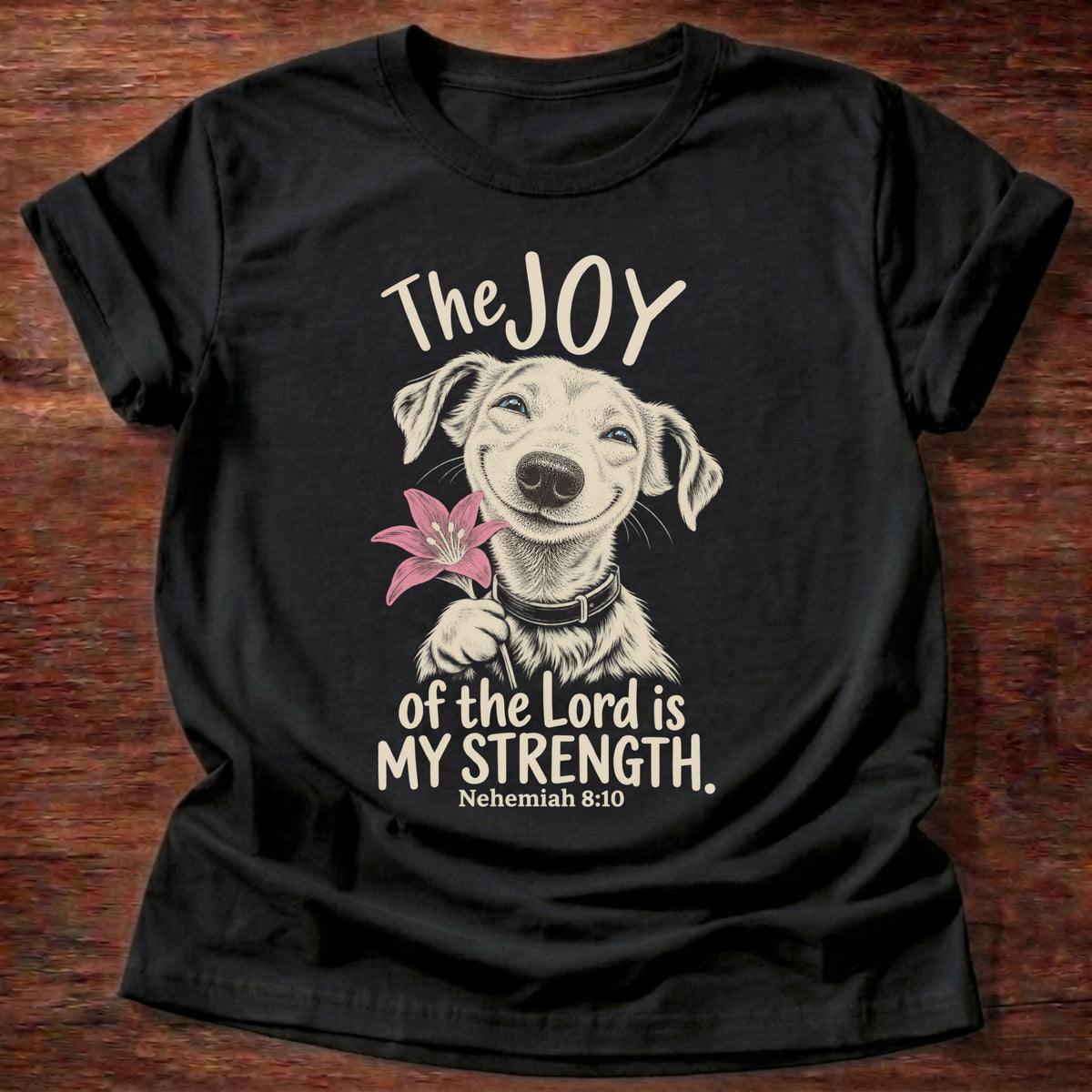 Black t-shirt printed with a happy smiling pup holding a flower graphic and “The joy of the Lord is my strength.” Nehemiah 8:10 Christian shirt