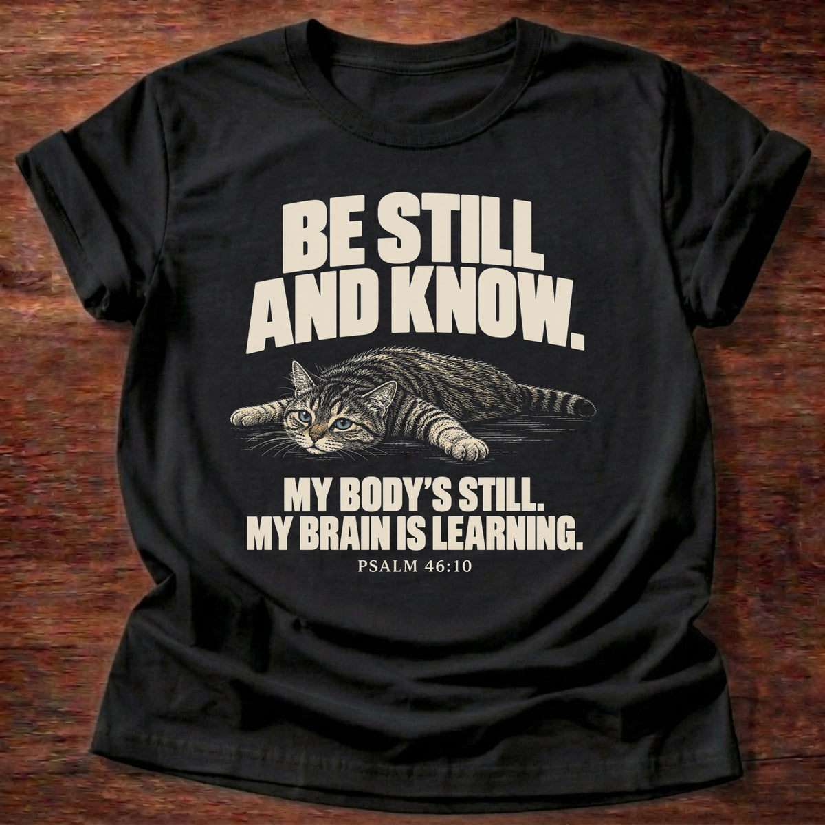 Brain Is Learning T-Shirt in Black featuring a relaxed cat stretched out lying down and Psalm 46:10 overthinking humor design