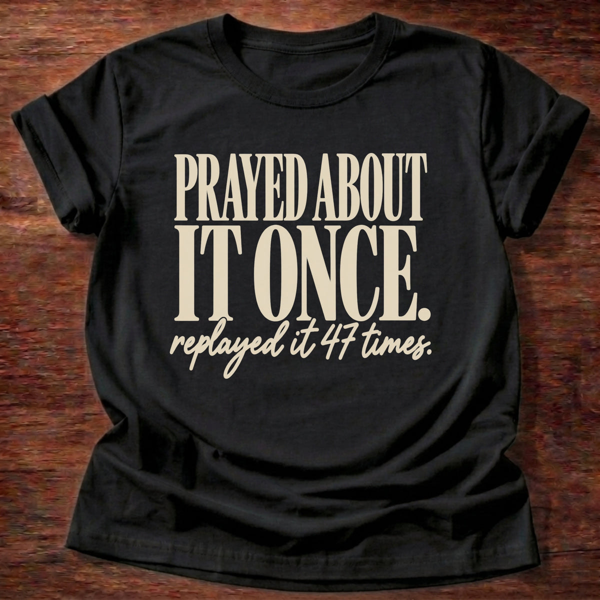Replayed It Forty-Seven T-Shirt in Black featuring Prayed About It Once replayed it 47 times funny Christian overthinker typography design with script punchline