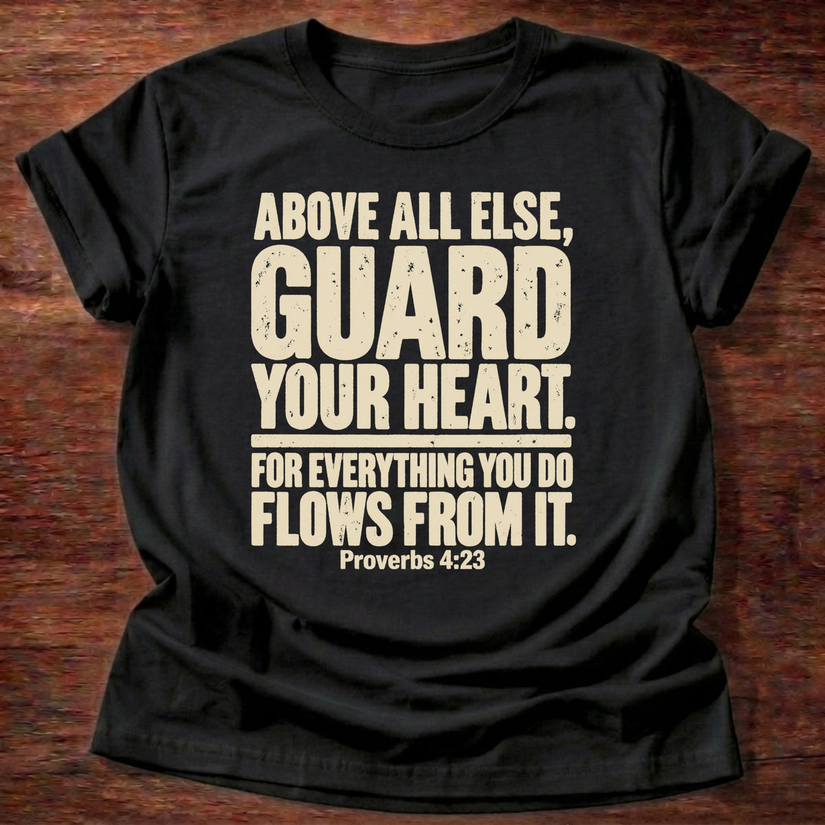Black t-shirt printed with bold stacked typography graphic and “Above all else, guard your heart, for everything you do flows from it.” Proverbs 4:23 Christian shirt