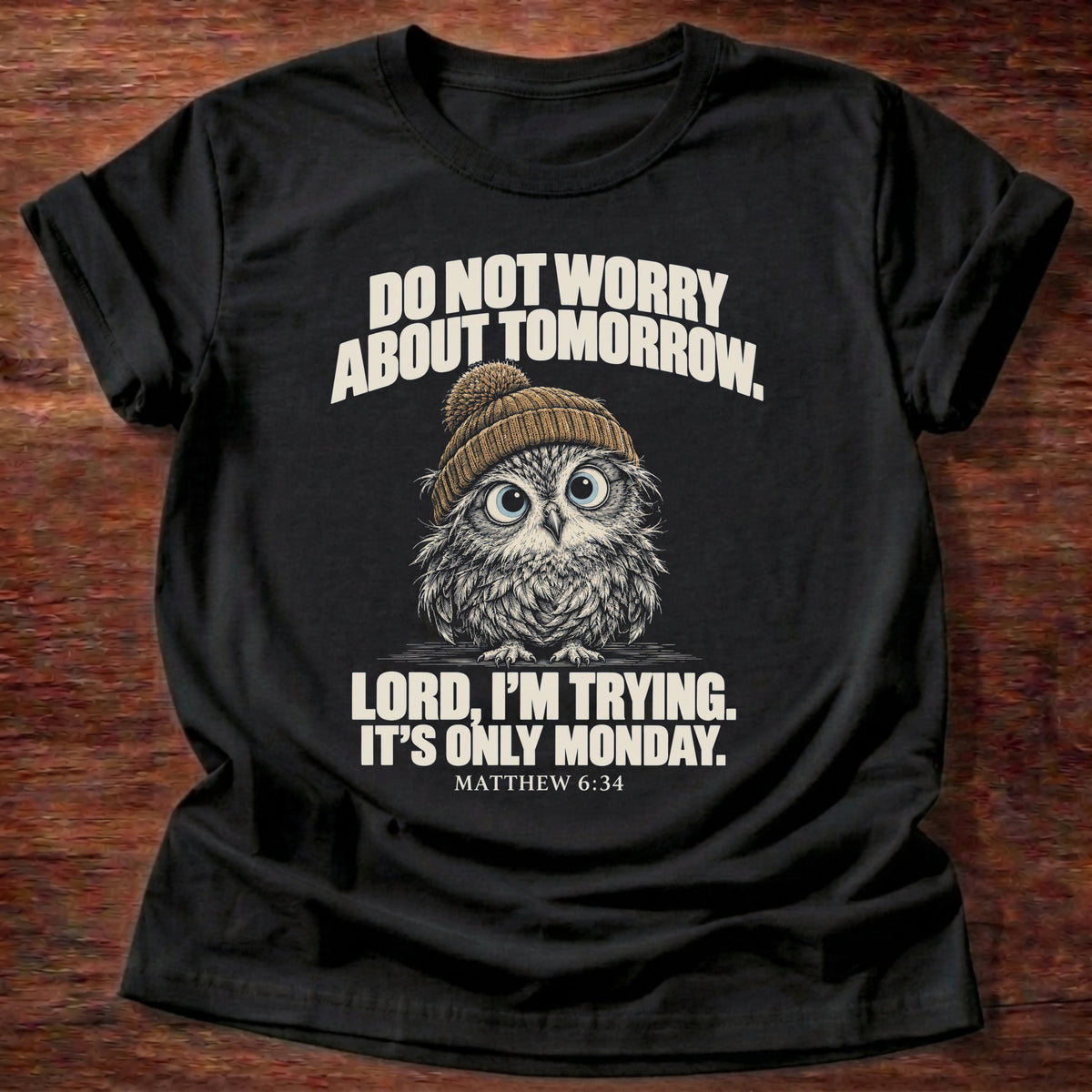 Only Monday T-Shirt in Black featuring a wide-eyed owl in a knit beanie and Matthew 6:34 worry humor design
