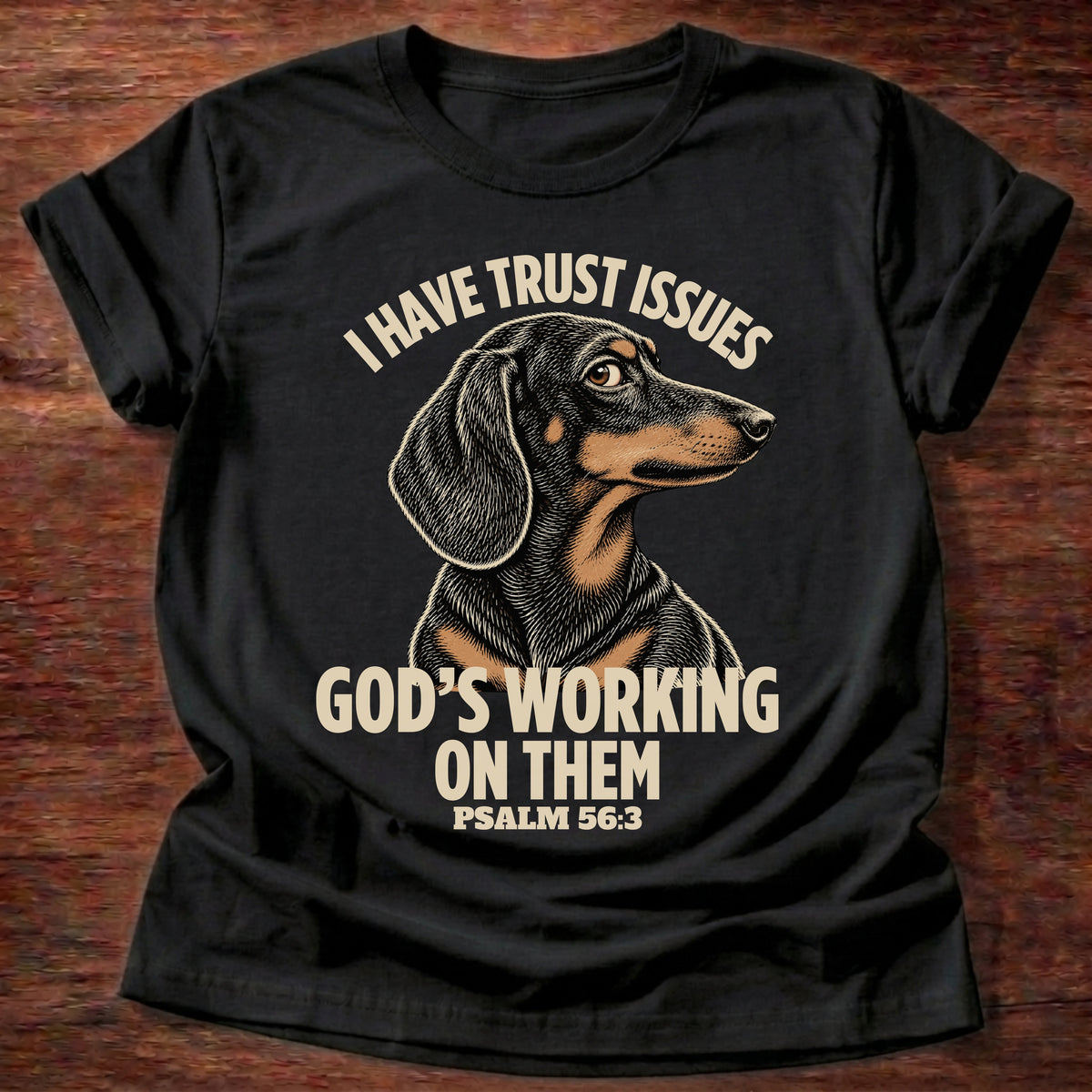 Black t-shirt printed with a wary dachshund puppy and “I have trust issues. God's working on them.” Psalm 56:3 Christian shirt