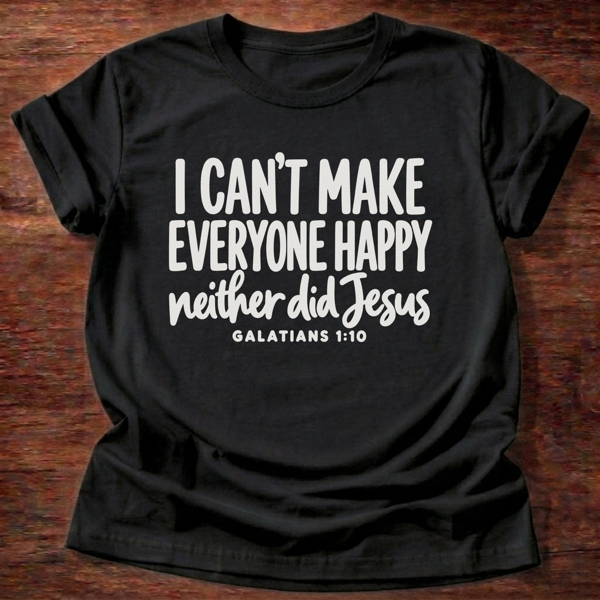Black t-shirt printed with bold hand-lettered typography graphic and “I can't make everyone happy. Neither did Jesus.” Galatians 1:10 Christian shirt