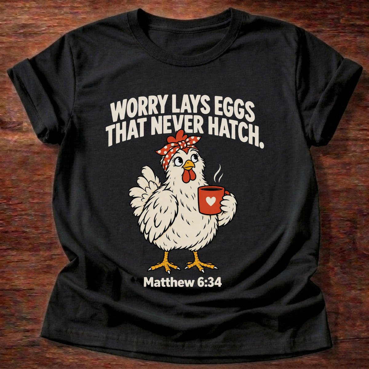 Black t-shirt printed with a chicken holding a tea cup graphic and 'Worry lays eggs that never hatch. I bring it to God.' Matthew 6:34 faith based gift