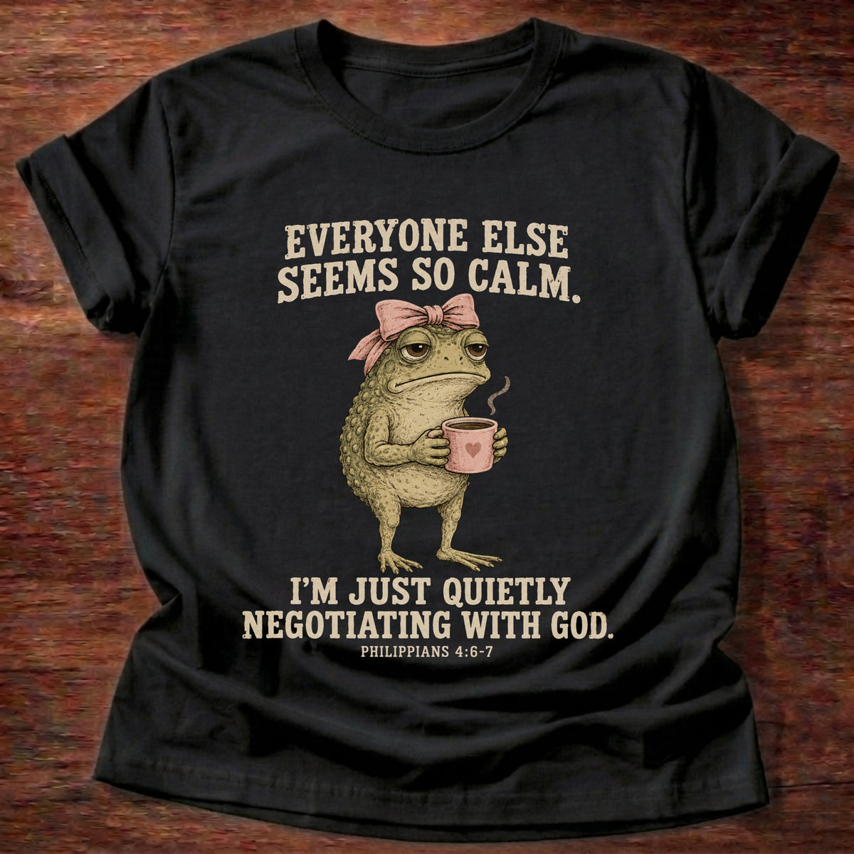 Black t-shirt printed with a possum holding a tea cup graphic and 'Everyone else seems so calm. I'm just quietly negotiating with God.' Philippians 4:6-7 faith based gift