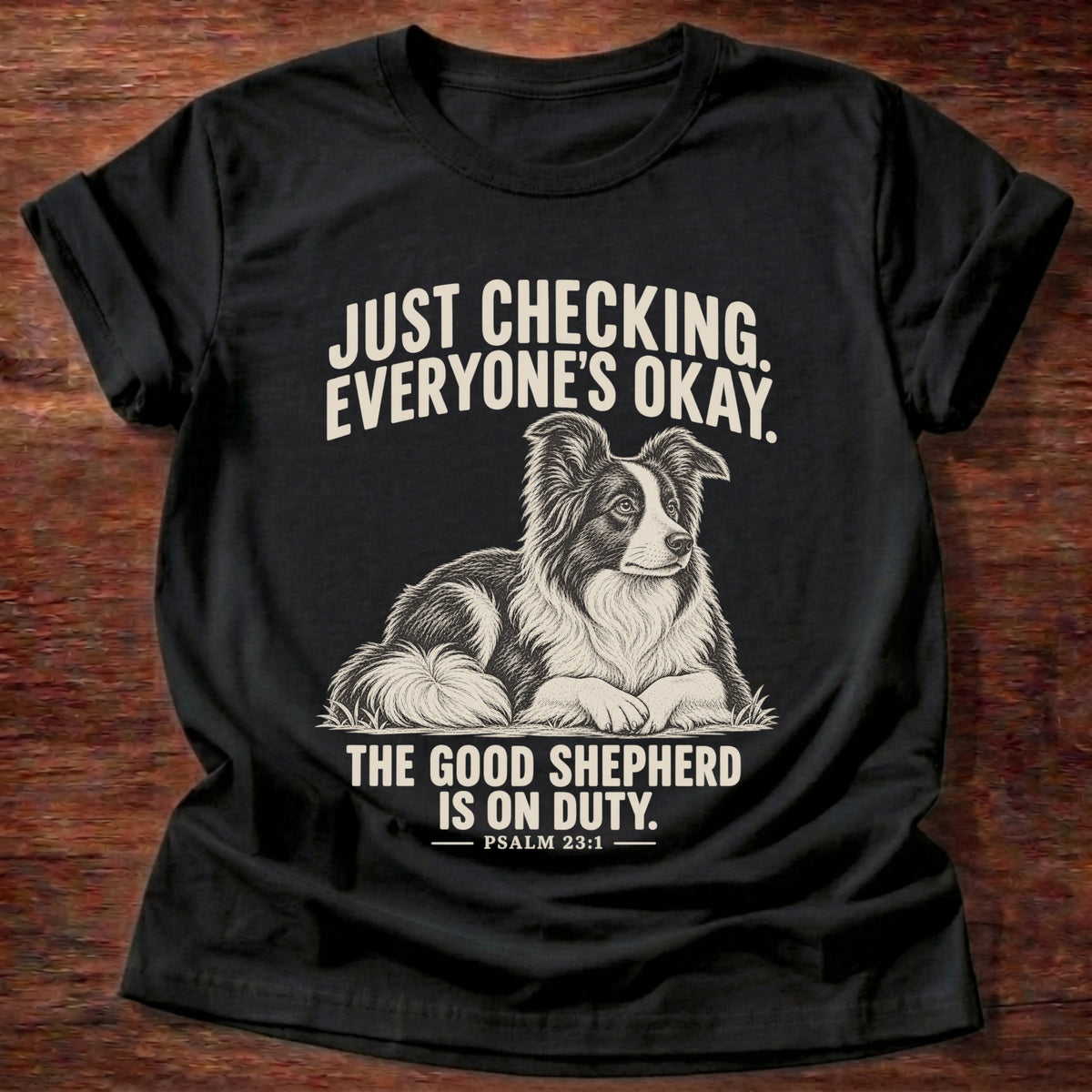 Black t-shirt printed with a border collie lying watchfully in the grass graphic and 'Just checking. Everyone's okay. The good shepherd is on duty.' Psalm 23:1 faith based gift