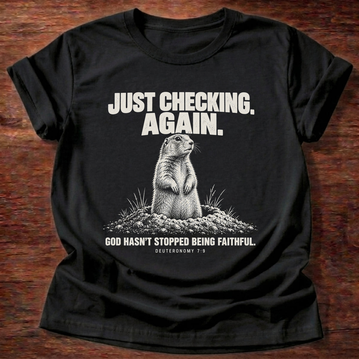 Black t-shirt printed with a prairie dog popping up out of its burrow graphic and 'Just checking. Again. God hasn't stopped being faithful.' Deuteronomy 7:9 faith based gift
