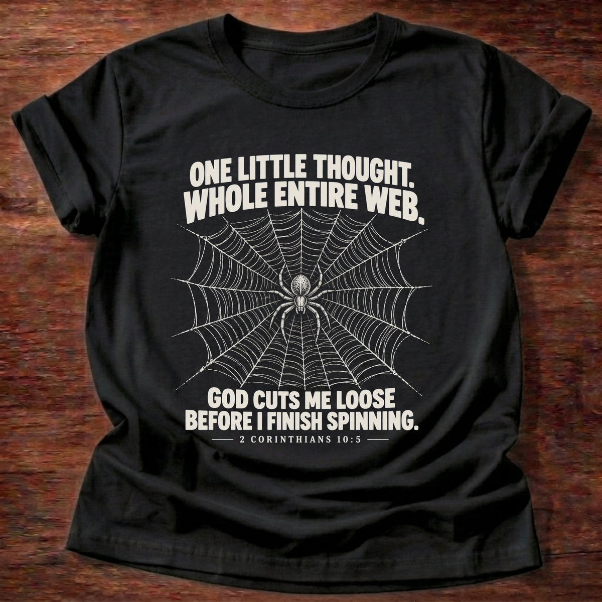 Black t-shirt printed with a spider at the center of its web graphic and 'One little thought. Whole entire web. God cuts me loose before I finish spinning.' 2 Corinthians 10:5 faith based gift