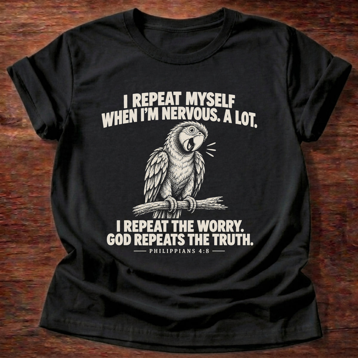 Black t-shirt printed with a parrot squawking on a perch graphic and 'I repeat myself when I'm nervous. A lot. I repeat the worry. God repeats the truth.' Philippians 4:6 faith based gift