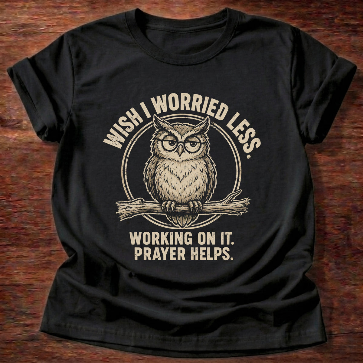 Black t-shirt printed with a worried owl graphic and 'Wish I worried less. Working on it. Prayer helps.' 1 Peter 5:7 faith based gift