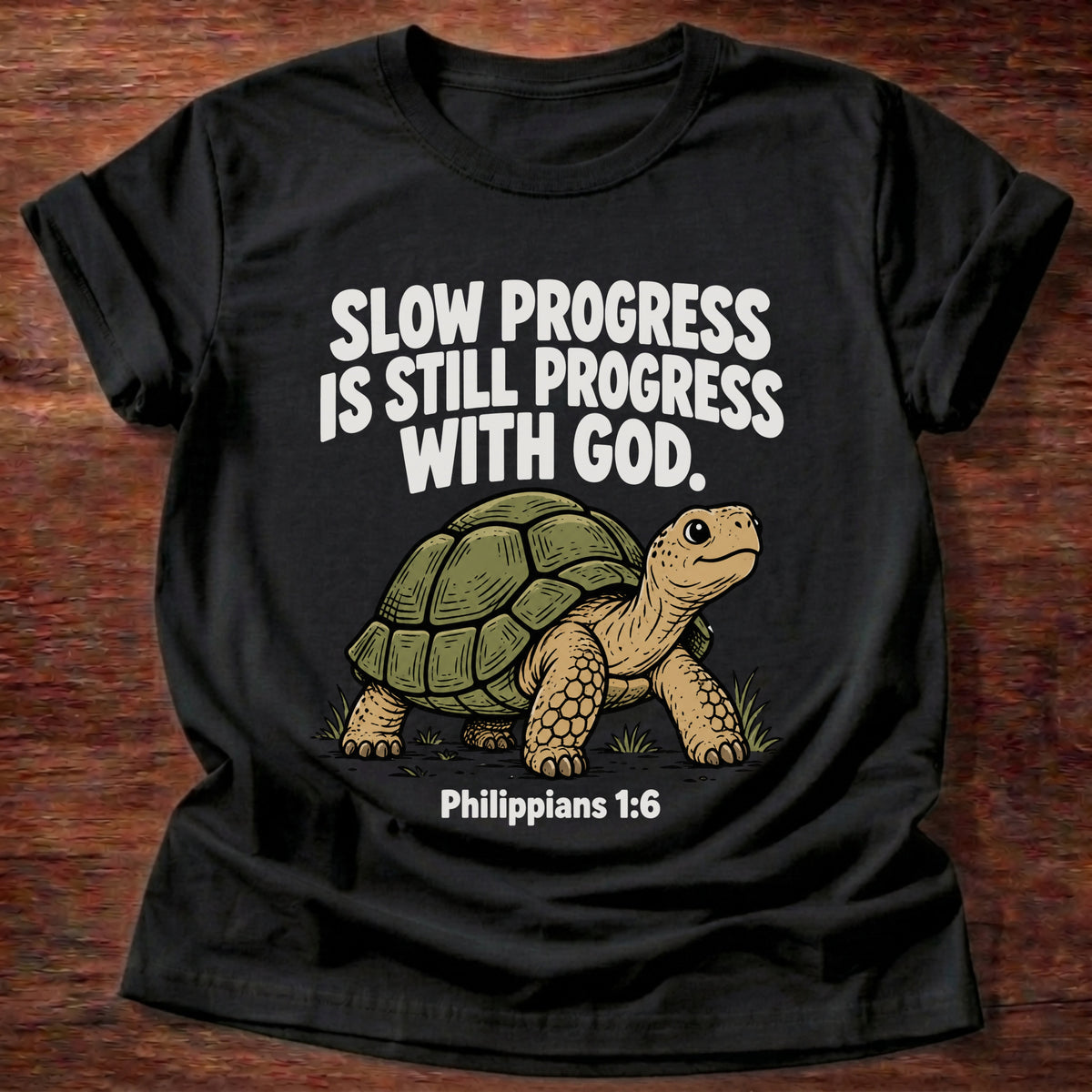 Black t-shirt printed with a turtle graphic and 'Slow progress is still progress with God.' Philippians 1:6 faith based gift