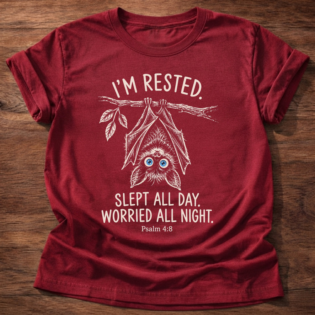 Cherry Red t-shirt printed with an upside-down hanging bat graphic and “I'm rested. Slept all day. Worried all night.” Psalm 4:8 Christian shirt