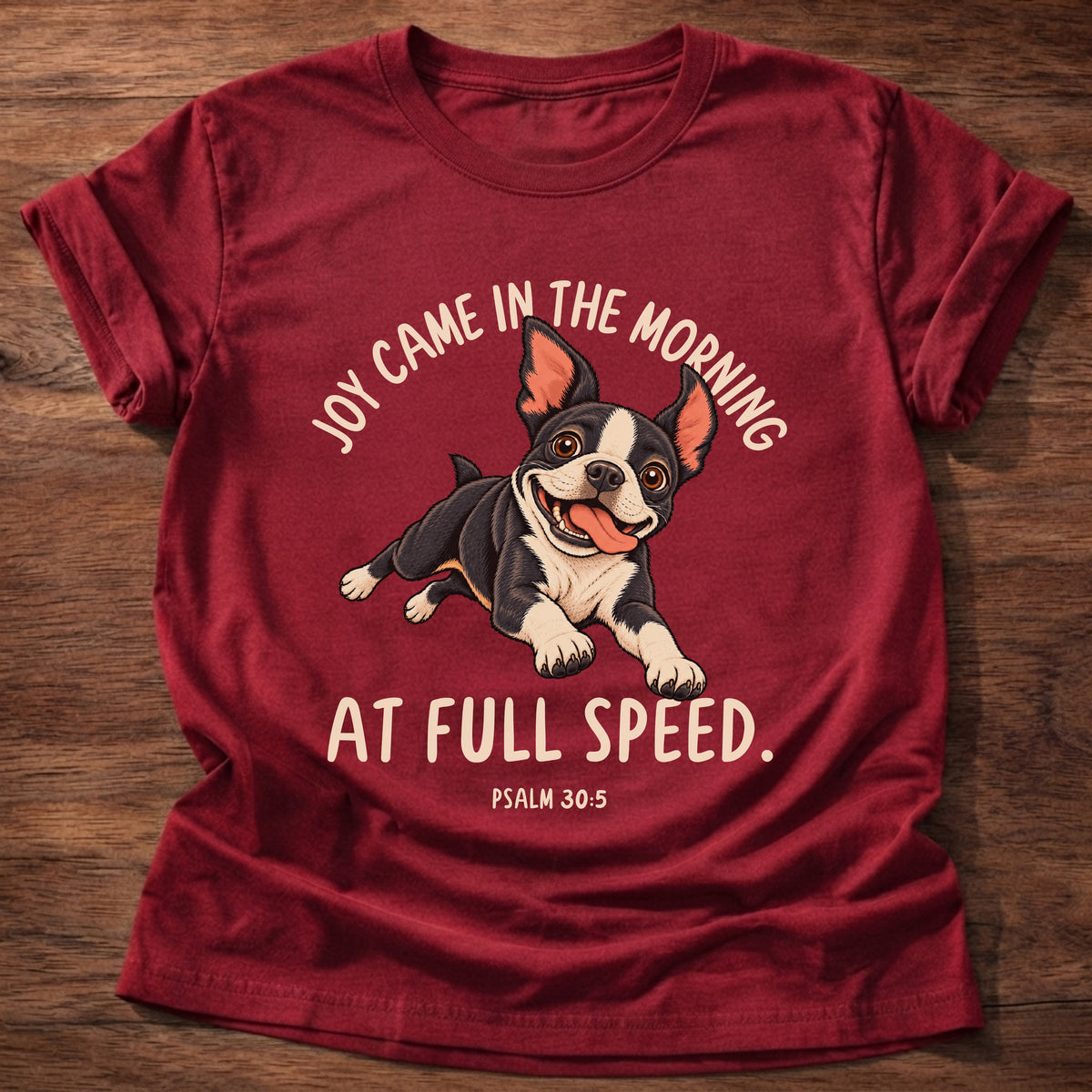 Cherry Red t-shirt printed with a Boston terrier puppy running full speed and “Joy came in the morning. At full speed.” Psalm 30:5 Christian shirt