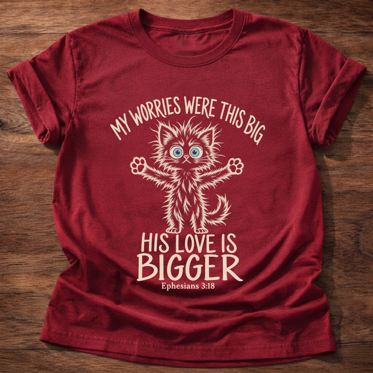 Cherry Red t-shirt printed with a wide-eyed fluffy kitten stretching its arms wide graphic and “My worries were this big. His love is bigger.” Ephesians 3:18 Christian shirt