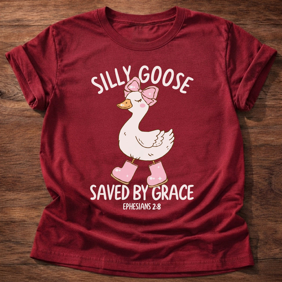 Cherry Red t-shirt printed with a goose wearing a pink bow and pink boots and “Silly Goose. Saved by Grace.” Ephesians 2:8 Christian shirt