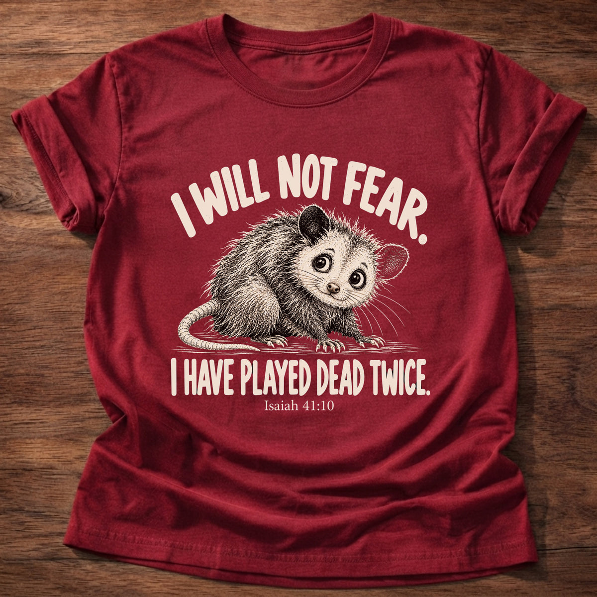 Cherry Red t-shirt printed with a wide-eyed opossum graphic and “I will not fear. I have played dead twice.” Isaiah 41:10 Christian shirt