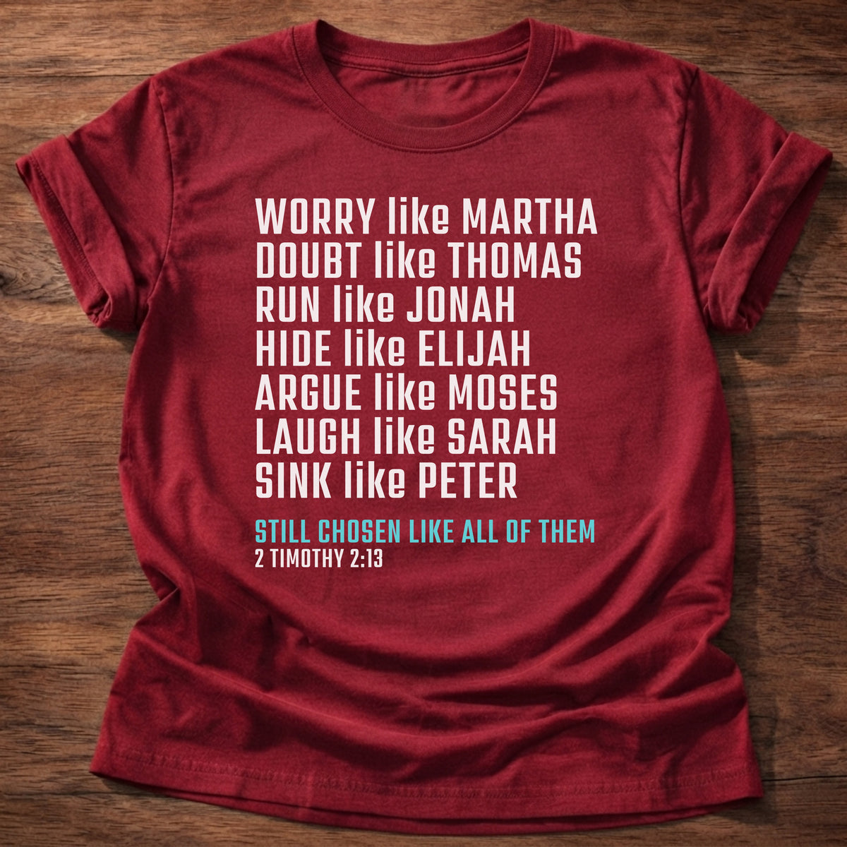 Cherry Red t-shirt printed with bold stacked typography listing Bible characters graphic and “Worry like Martha. Doubt like Thomas. Sink like Peter. Still chosen like all of them.” 2 Timothy 2:13 Christian shirt