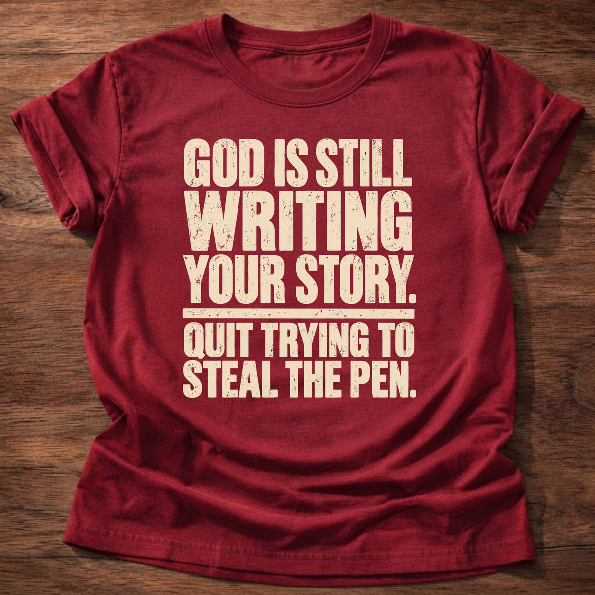 Cherry Red t-shirt printed with bold stacked typography graphic and “God is still writing your story. Quit trying to steal the pen.” Philippians 1:6 Christian shirt